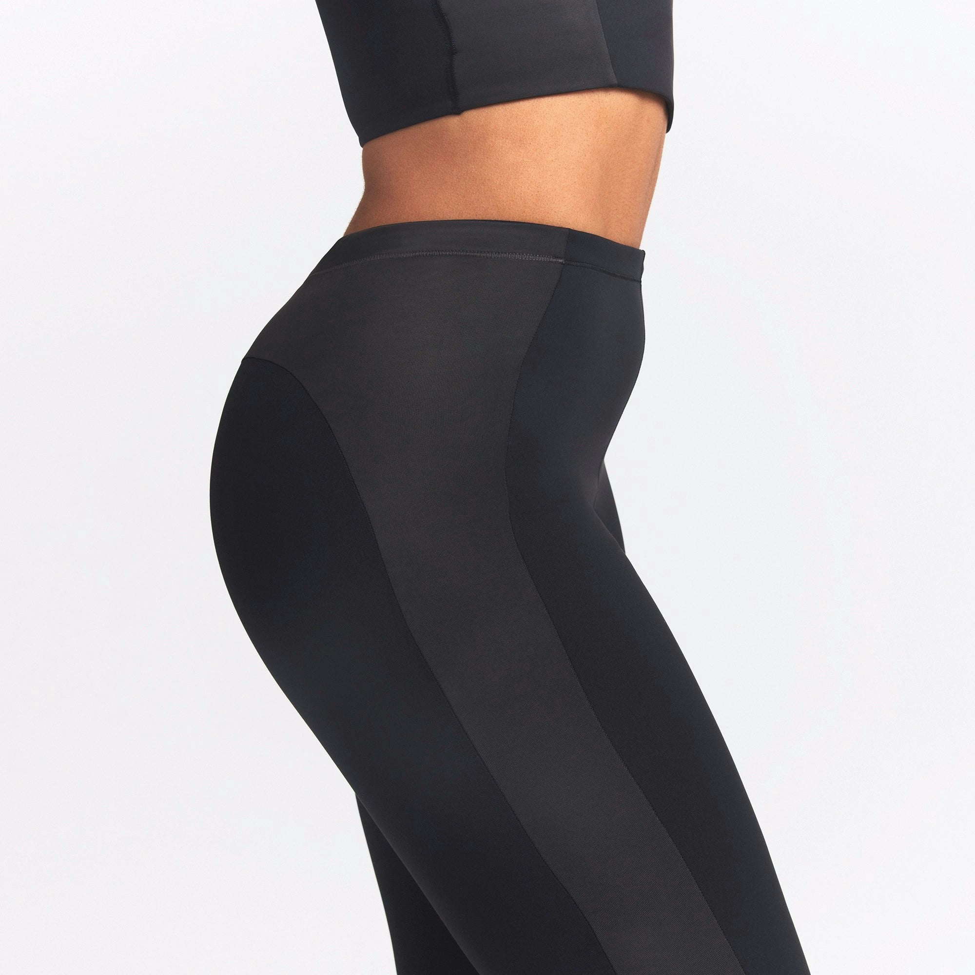 NikeSKIMS MATTE AND SHINE 26" LEGGING | OBSIDIAN/IGNEOUS ON A MODEL SIDE VIEW @ | FOCUS: 0.0, 1.0, 0.9