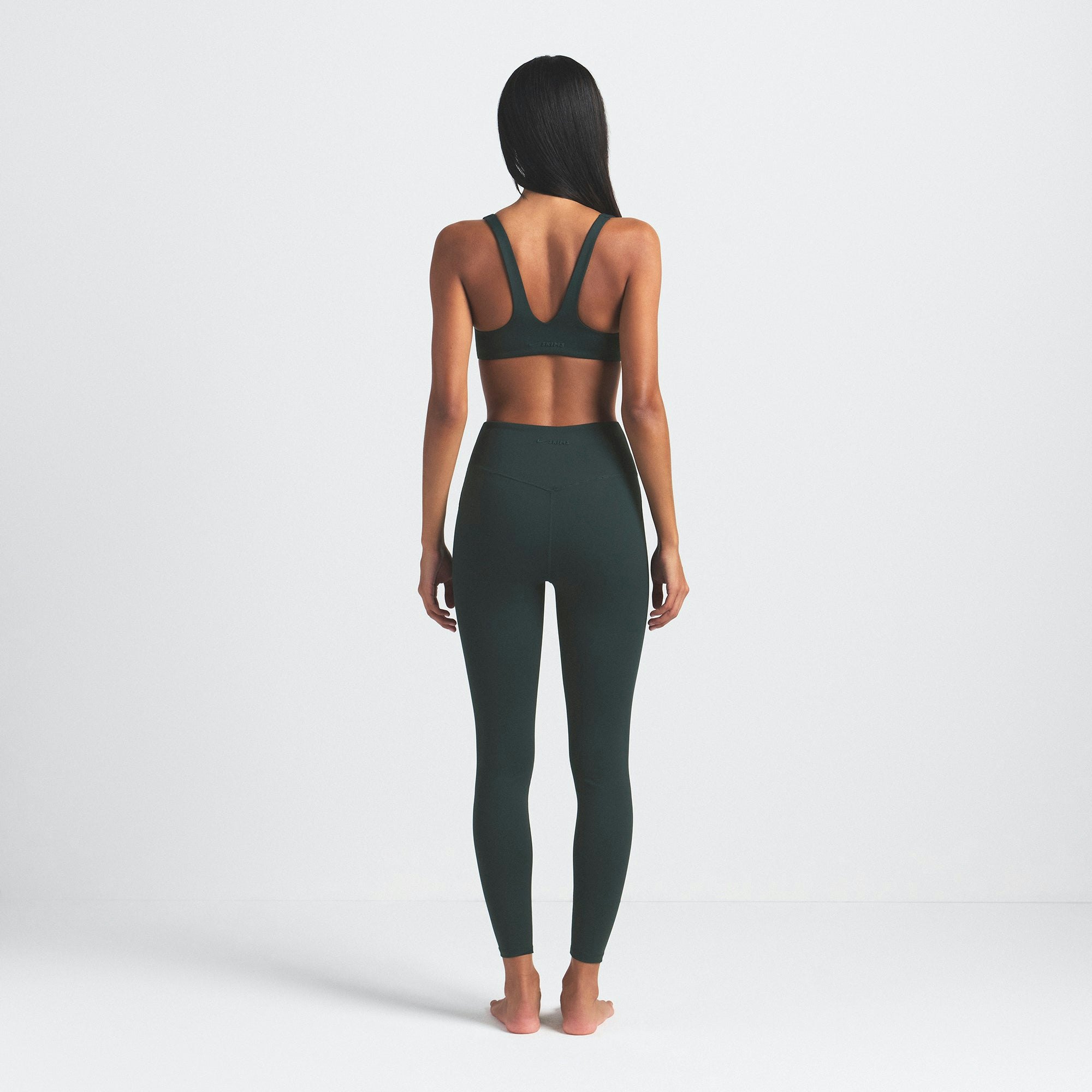NikeSKIMS MATTE 26" LEGGING | DARK TEAL ON A MODEL SIDE VIEW @ | FOCUS: 0.0, 1.0, 0.9
