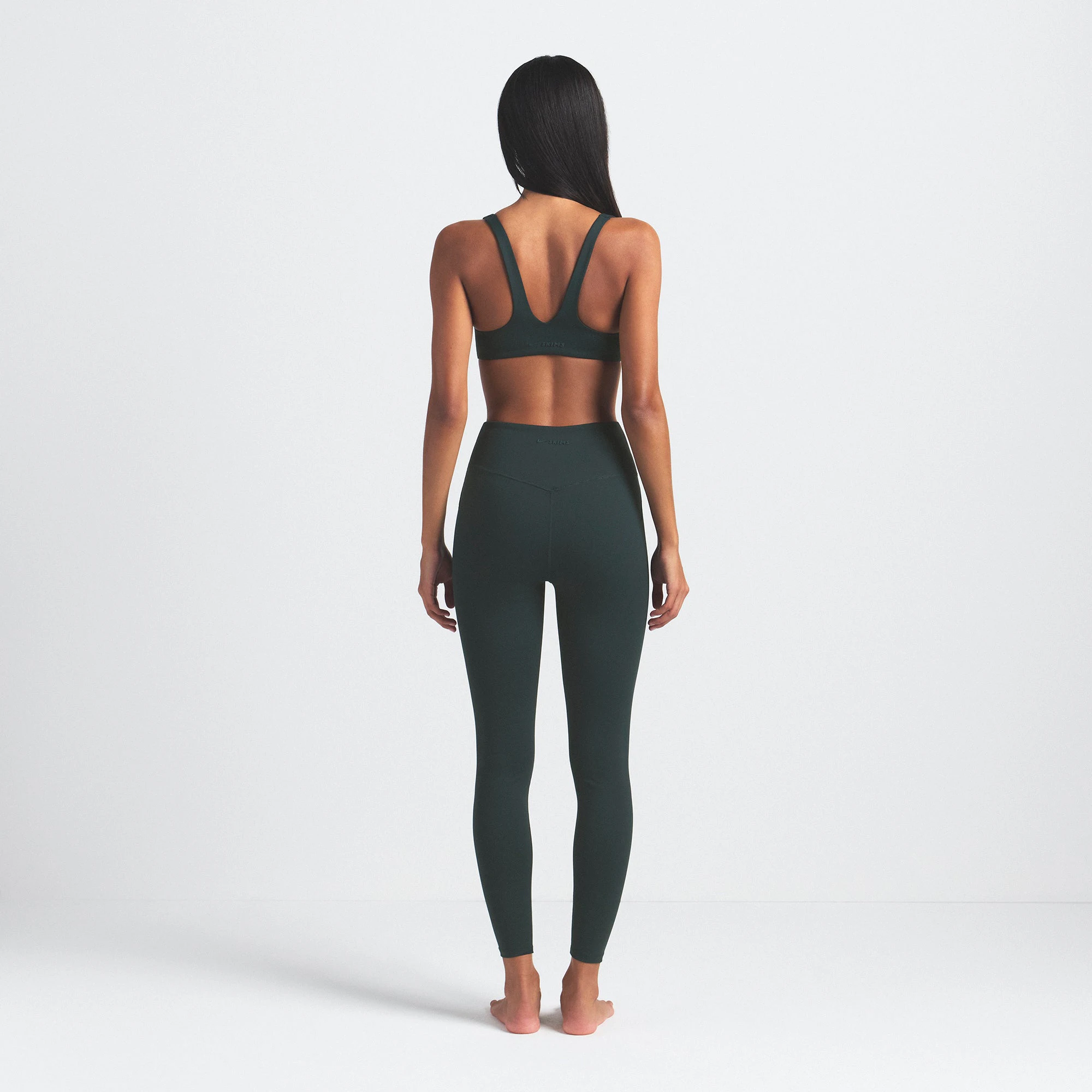 NikeSKIMS MATTE 26" LEGGING | DARK TEAL ON A MODEL SIDE VIEW @ | FOCUS: 0.0, 1.0, 0.9