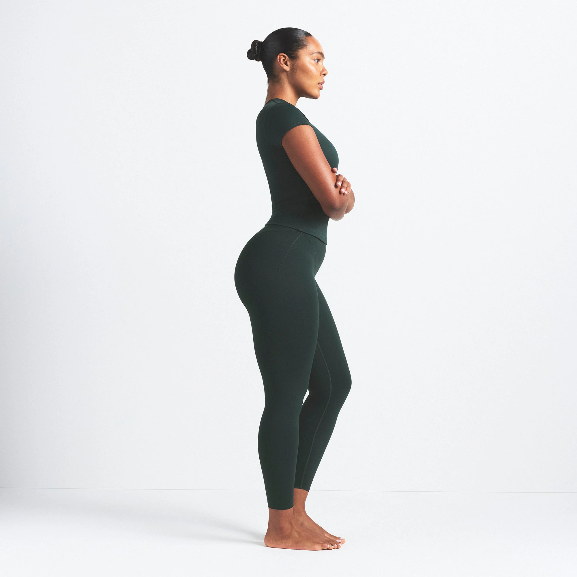 NikeSKIMS MATTE V-LINE 26" LEGGING | DARK TEAL ON A MODEL SIDE VIEW @ | FOCUS: 0.0, 1.0, 0.9