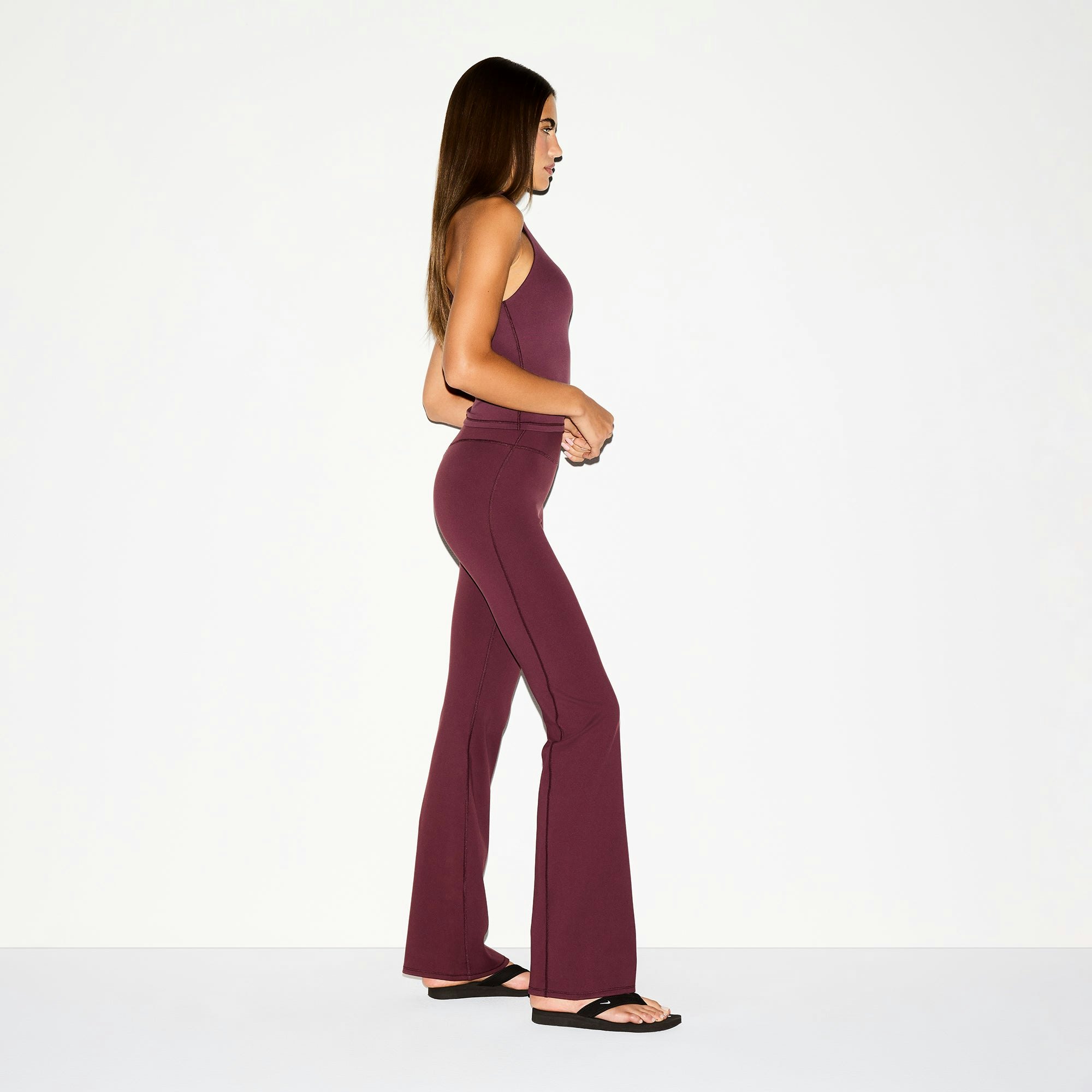 NikeSKIMS MATTE SLIM FLARE LEGGING | CURRANT ON A MODEL SIDE VIEW @ | FOCUS: 0.0, 1.0, 0.9