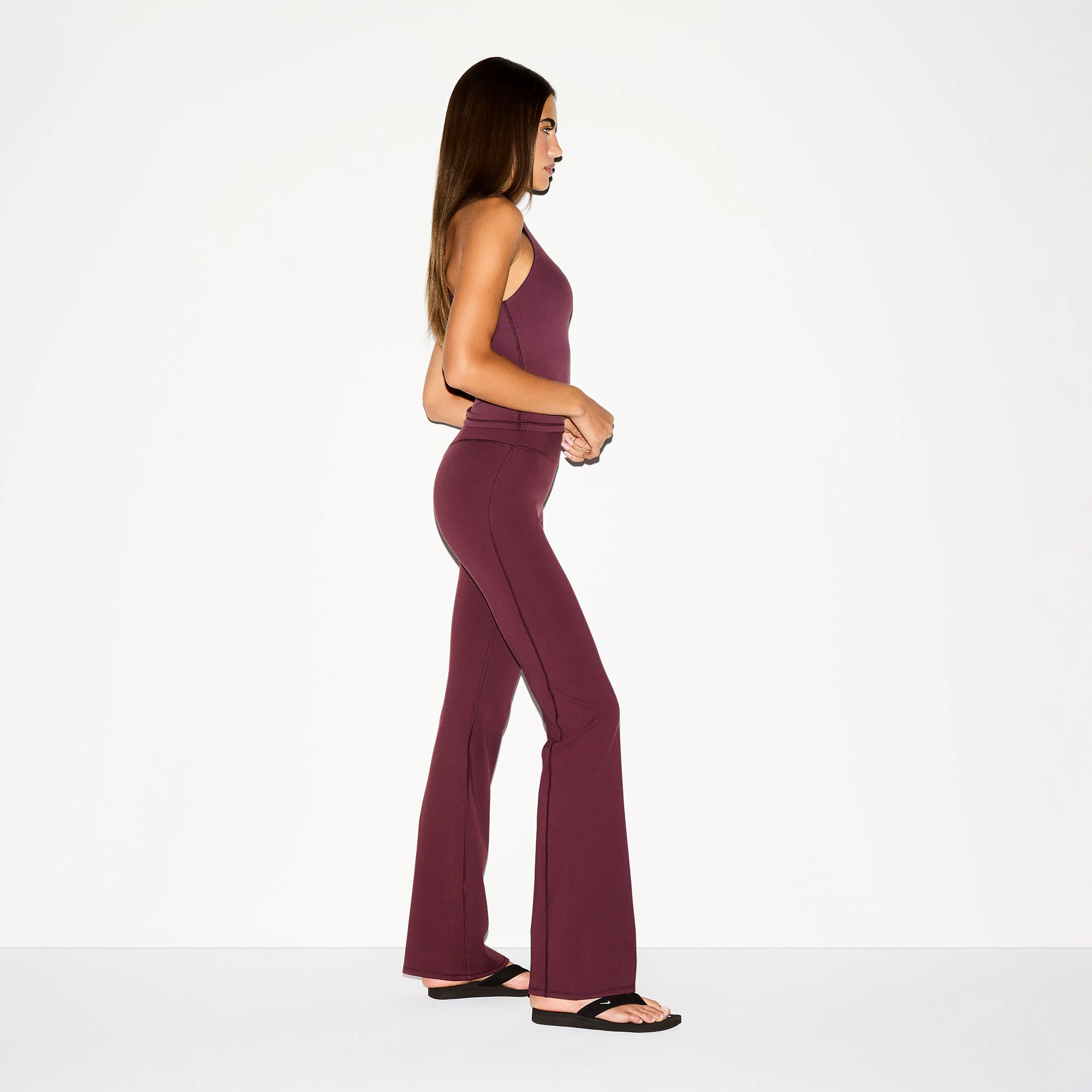 NikeSKIMS MATTE SLIM FLARE LEGGING | CURRANT ON A MODEL SIDE VIEW @ | FOCUS: 0.0, 1.0, 0.9