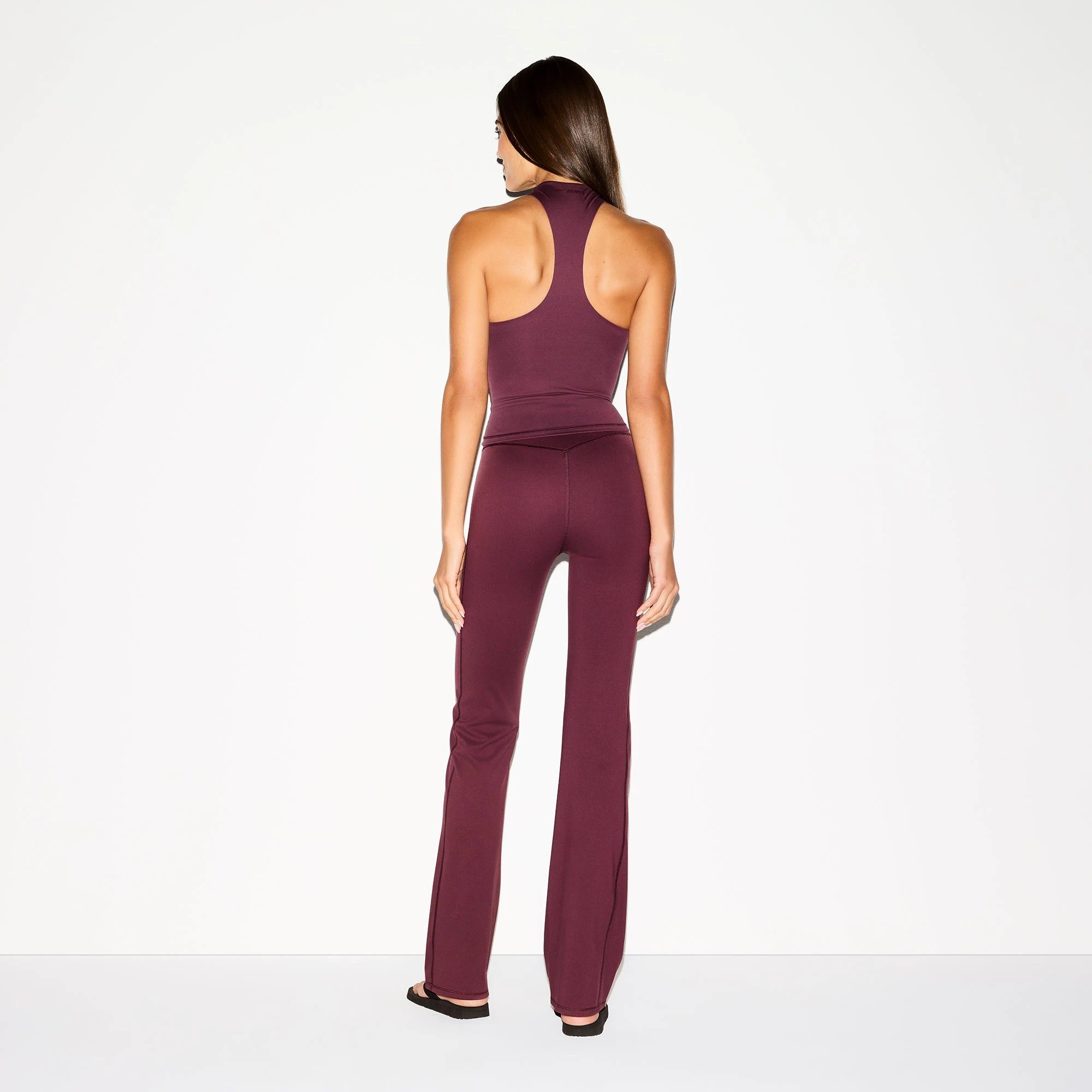 NikeSKIMS MATTE SLIM FLARE LEGGING | CURRANT ON A MODEL BACK VIEW @ | FOCUS: 0.0, 1.0, 0.9