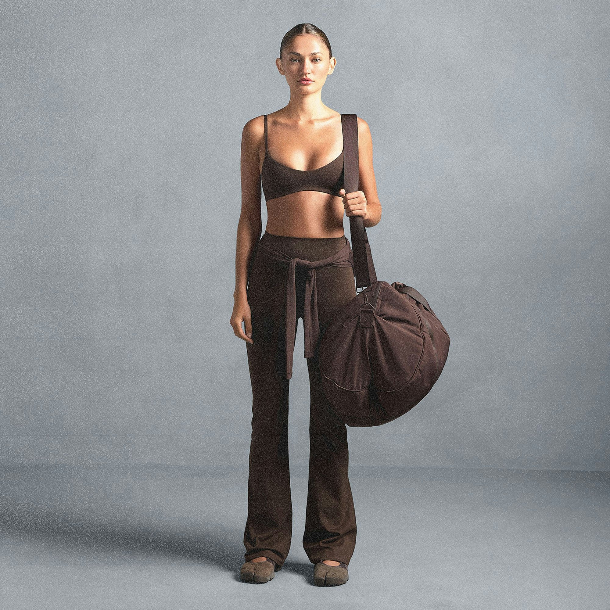 NikeSKIMS MATTE SLIM FLARE LEGGING | DARK SEPIA ON A MODEL SIDE VIEW @ | FOCUS: 0.0, 1.0, 0.9