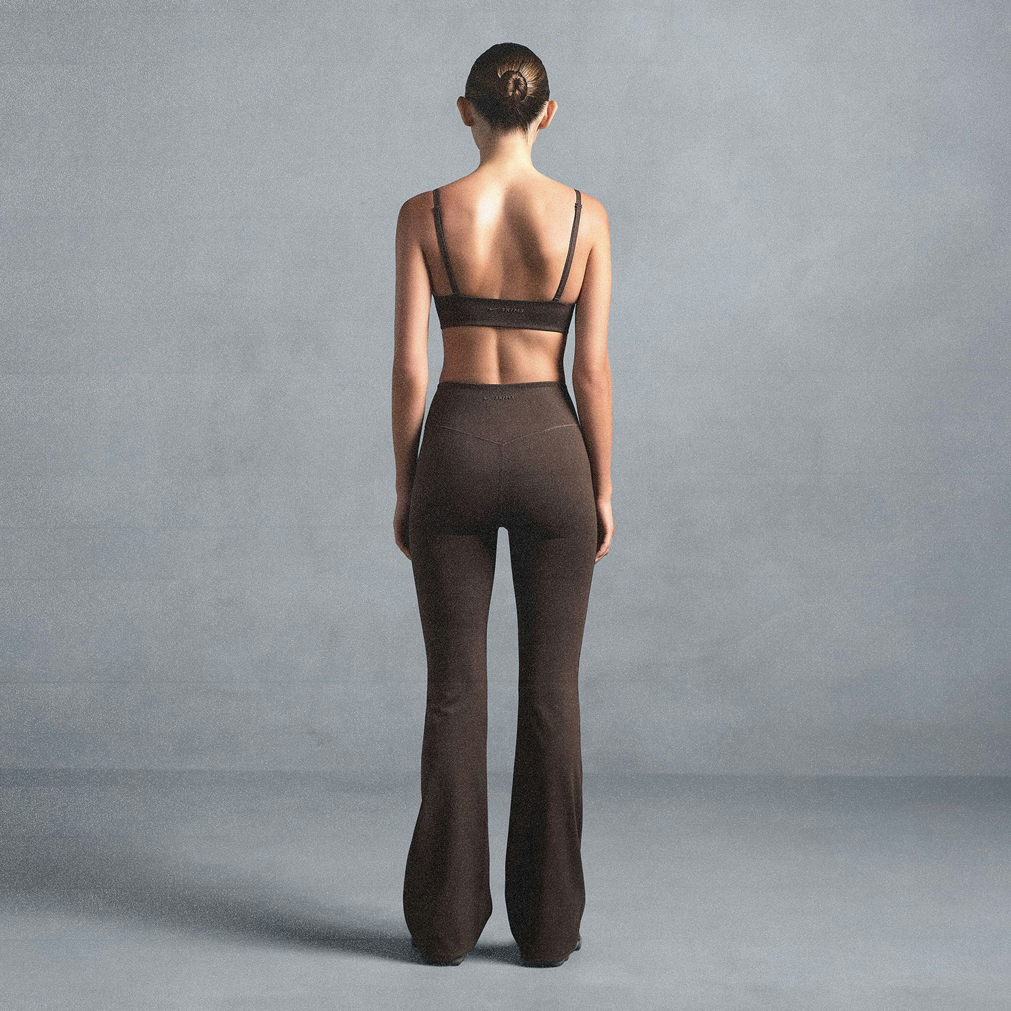 NikeSKIMS MATTE SLIM FLARE LEGGING | DARK SEPIA ON A MODEL SIDE VIEW @ | FOCUS: 0.0, 1.0, 0.9