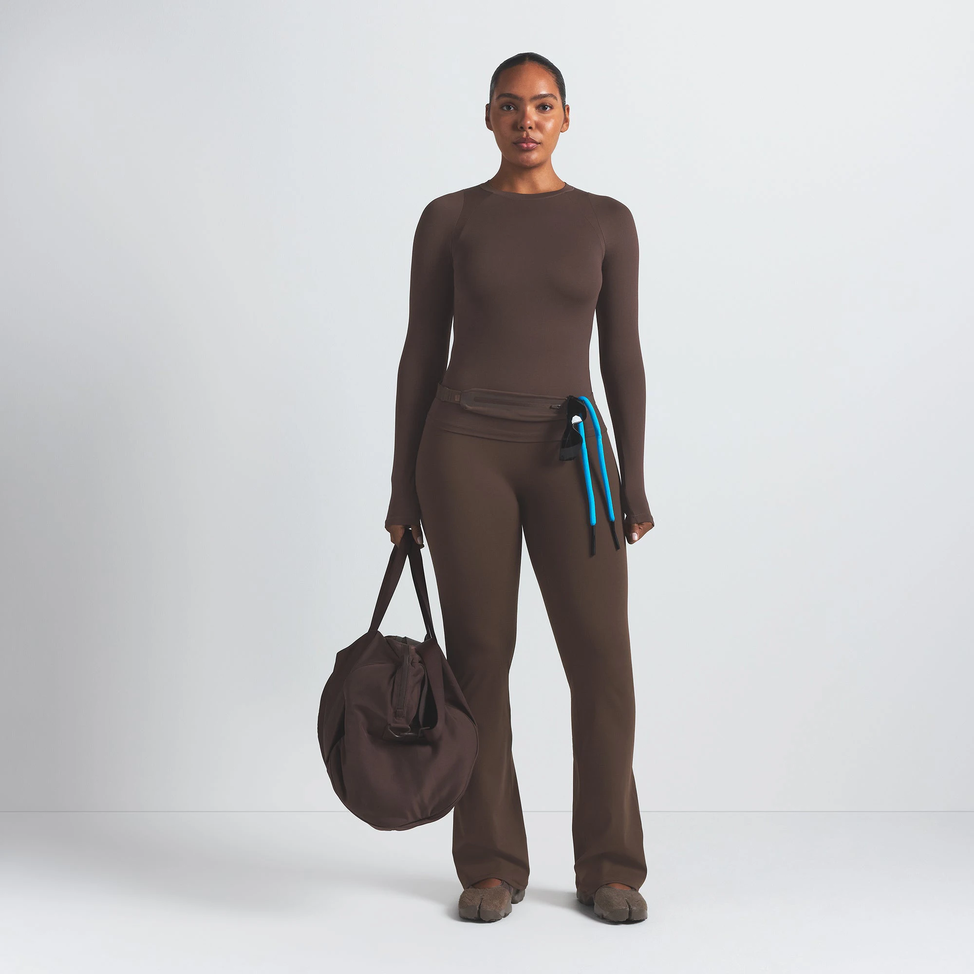 NikeSKIMS MATTE SLIM FLARE LEGGING | DARK SEPIA ON A MODEL FRONT VIEW @ | FOCUS: 0.9, 0.1, 0.7