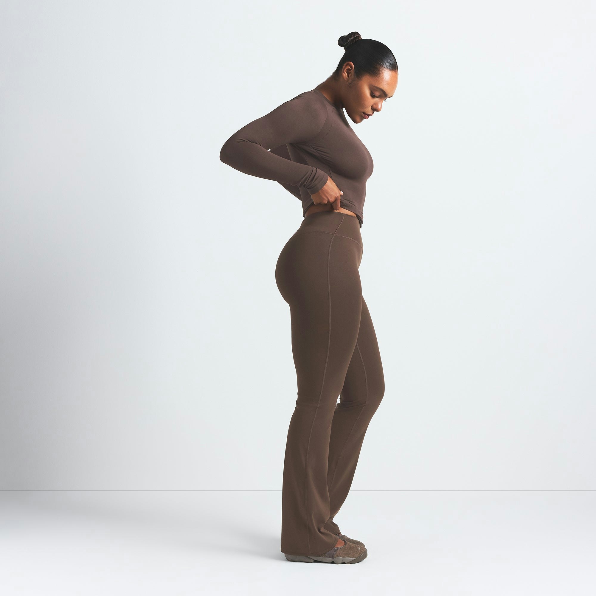 NikeSKIMS MATTE SLIM FLARE LEGGING | DARK SEPIA ON A MODEL SIDE VIEW