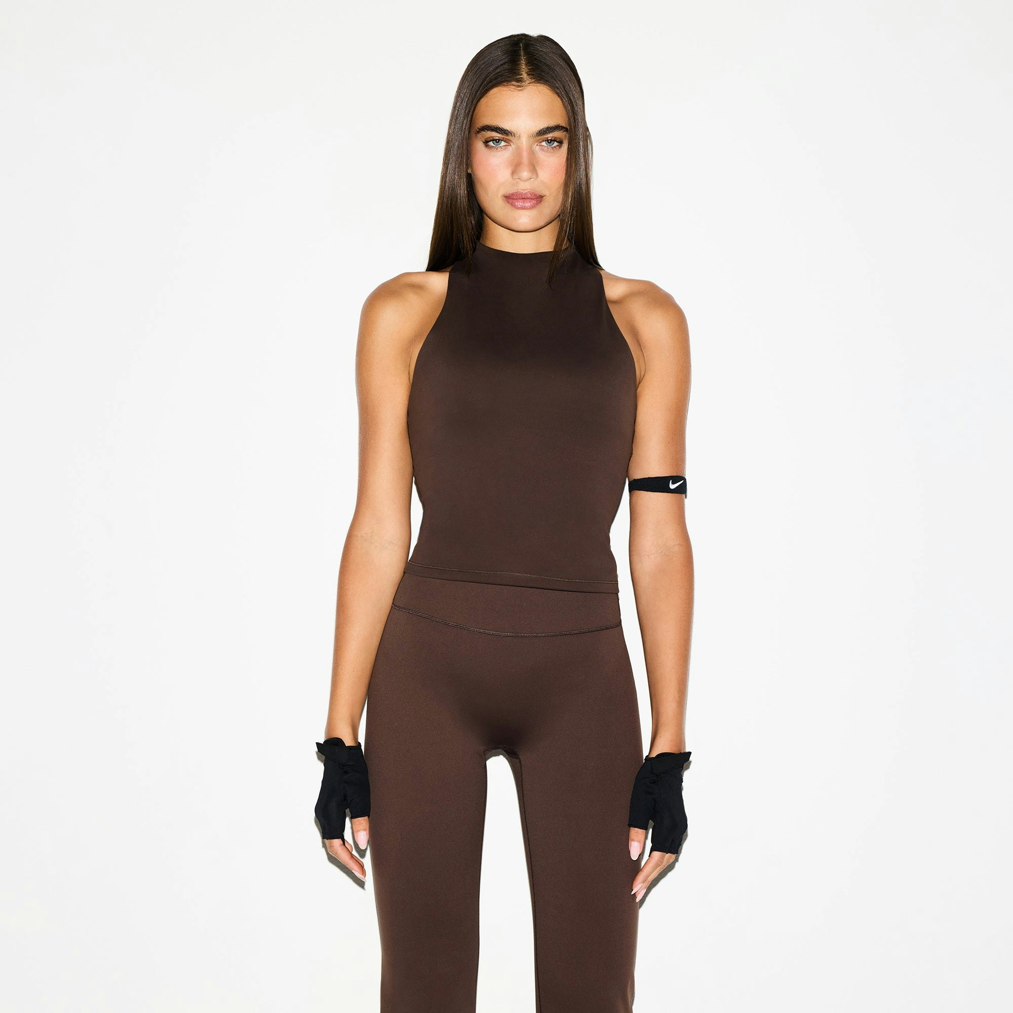 NikeSKIMS MATTE SLIM FLARE LEGGING | DARK SEPIA ON A MODEL FRONT VIEW @ | FOCUS: 0.0, 1.0, 0.9