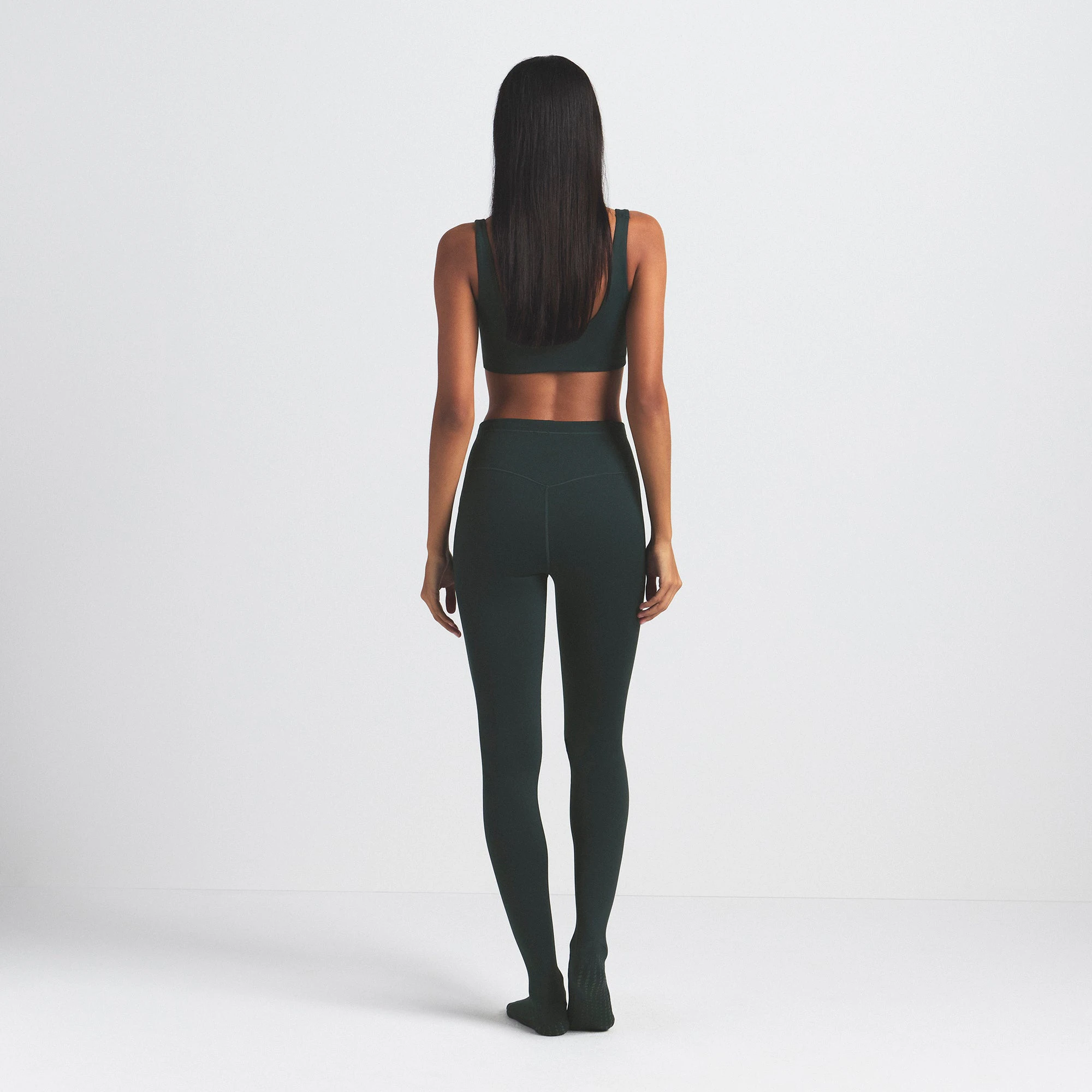 NikeSKIMS MATTE FOOTSIE GRIP LEGGING | DARK TEAL ON A MODEL SIDE VIEW @ | FOCUS: 0.0, 1.0, 0.9