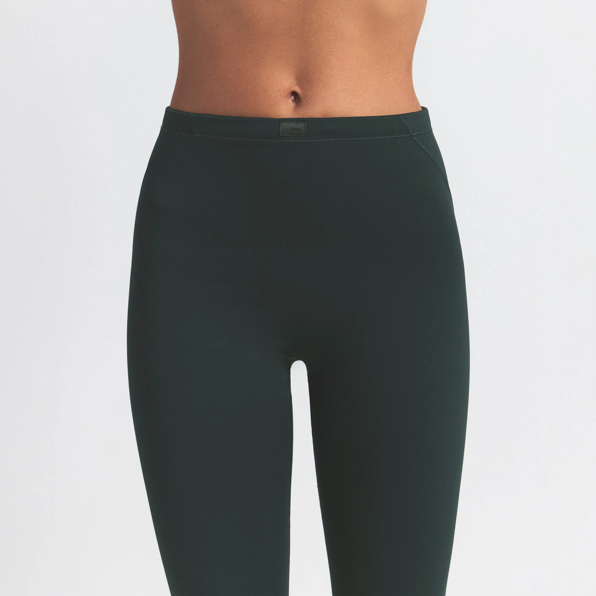 NikeSKIMS MATTE FOOTSIE GRIP LEGGING | DARK TEAL ON A MODEL SIDE VIEW @ | FOCUS: 0.0, 1.0, 0.9