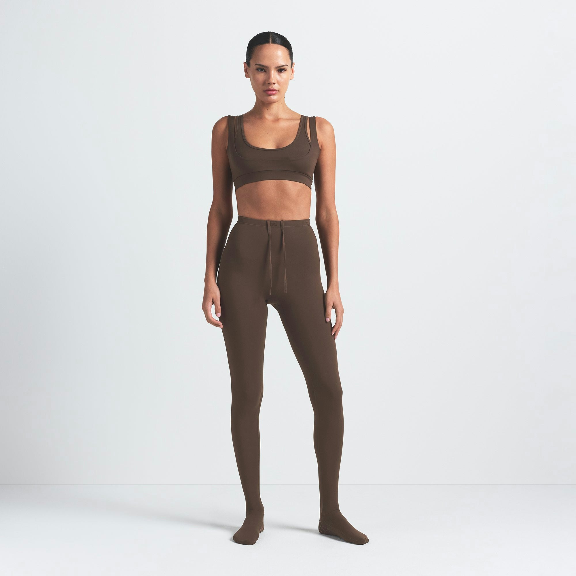 NikeSKIMS MATTE FOOTSIE GRIP LEGGING | DARK SEPIA ON A MODEL FRONT VIEW