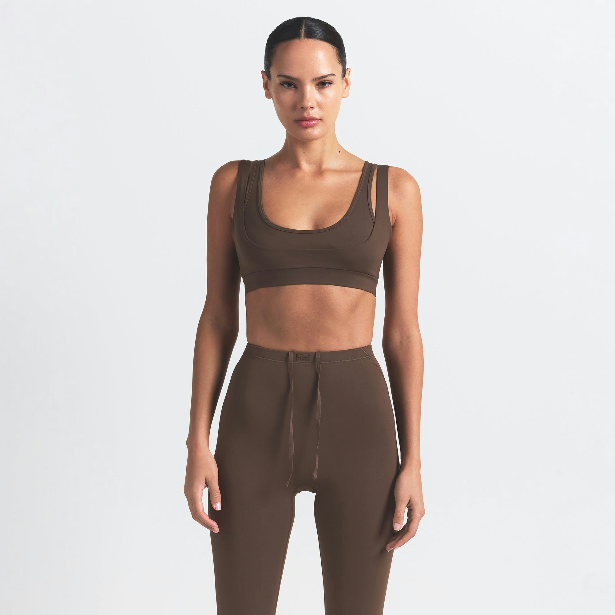 NikeSKIMS MATTE FOOTSIE GRIP LEGGING | DARK SEPIA ON A MODEL FRONT VIEW