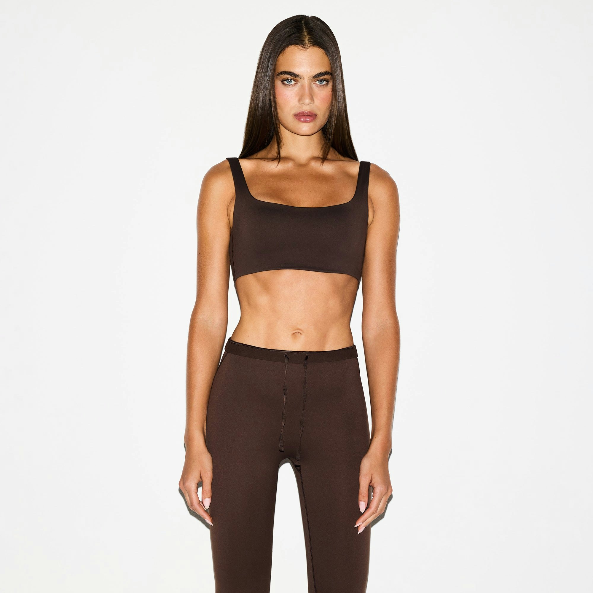 NikeSKIMS MATTE FOOTSIE GRIP LEGGING | DARK SEPIA ON A MODEL FRONT VIEW @ | FOCUS: 0.0, 1.0, 0.9