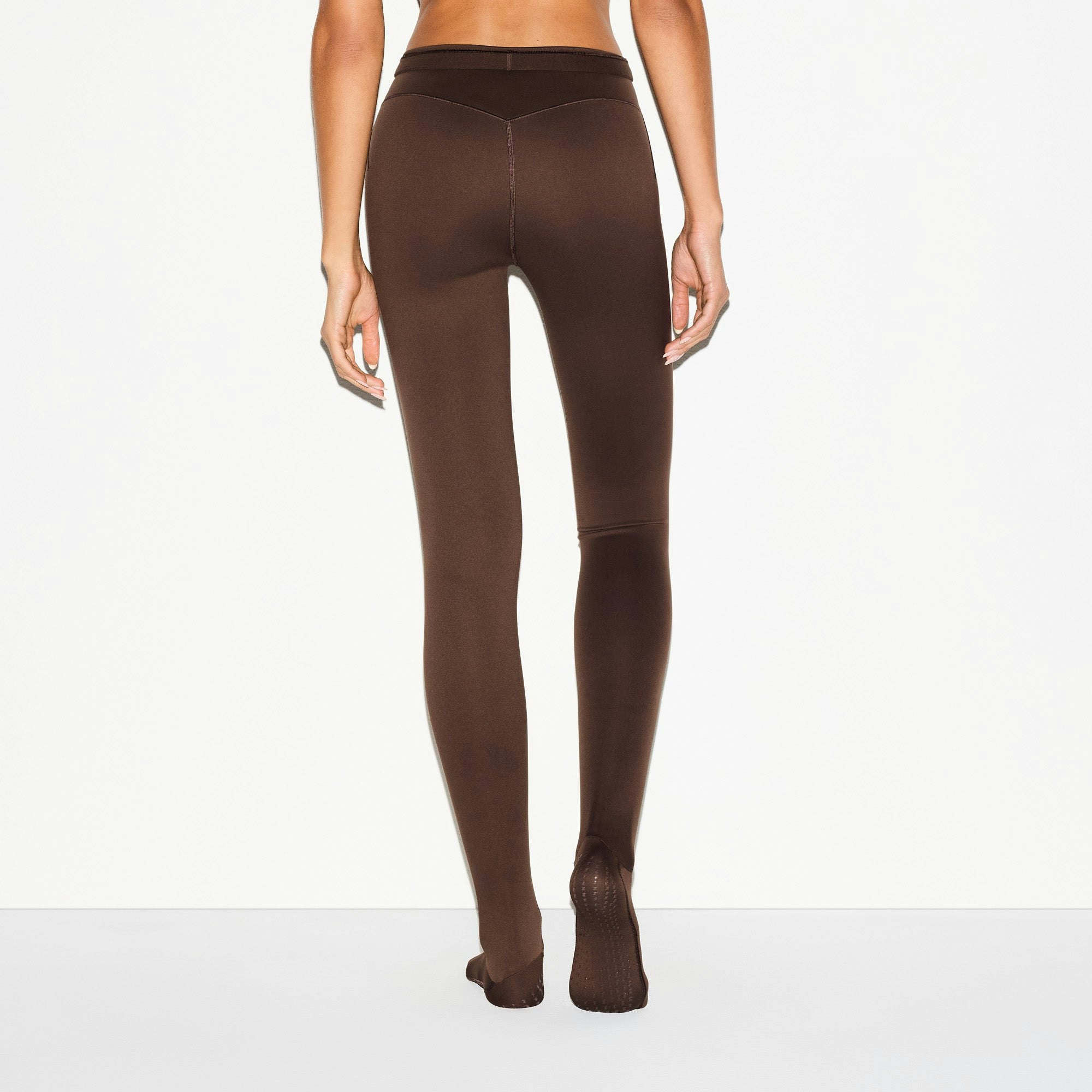 NikeSKIMS MATTE FOOTSIE GRIP LEGGING | DARK SEPIA ON A MODEL BACK VIEW @ | FOCUS: 0.0, 1.0, 0.9