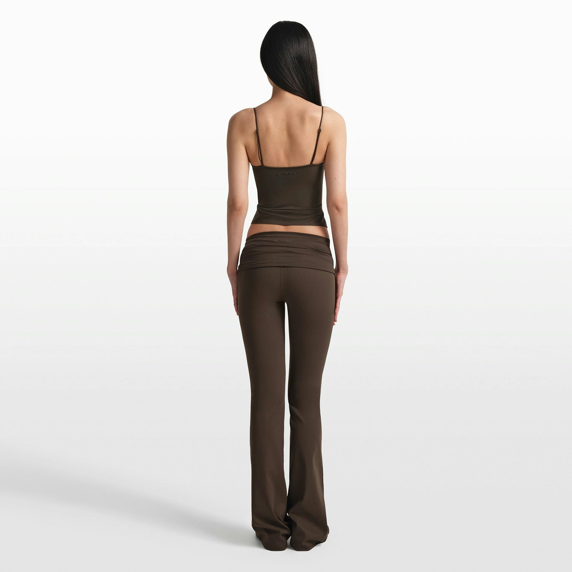 NikeSKIMS MATTE FOLDOVER SLIM FLARE LEGGING | DARK SEPIA ON A MODEL FRONT VIEW @ | FOCUS: 0.0, 1.0, 0.9
