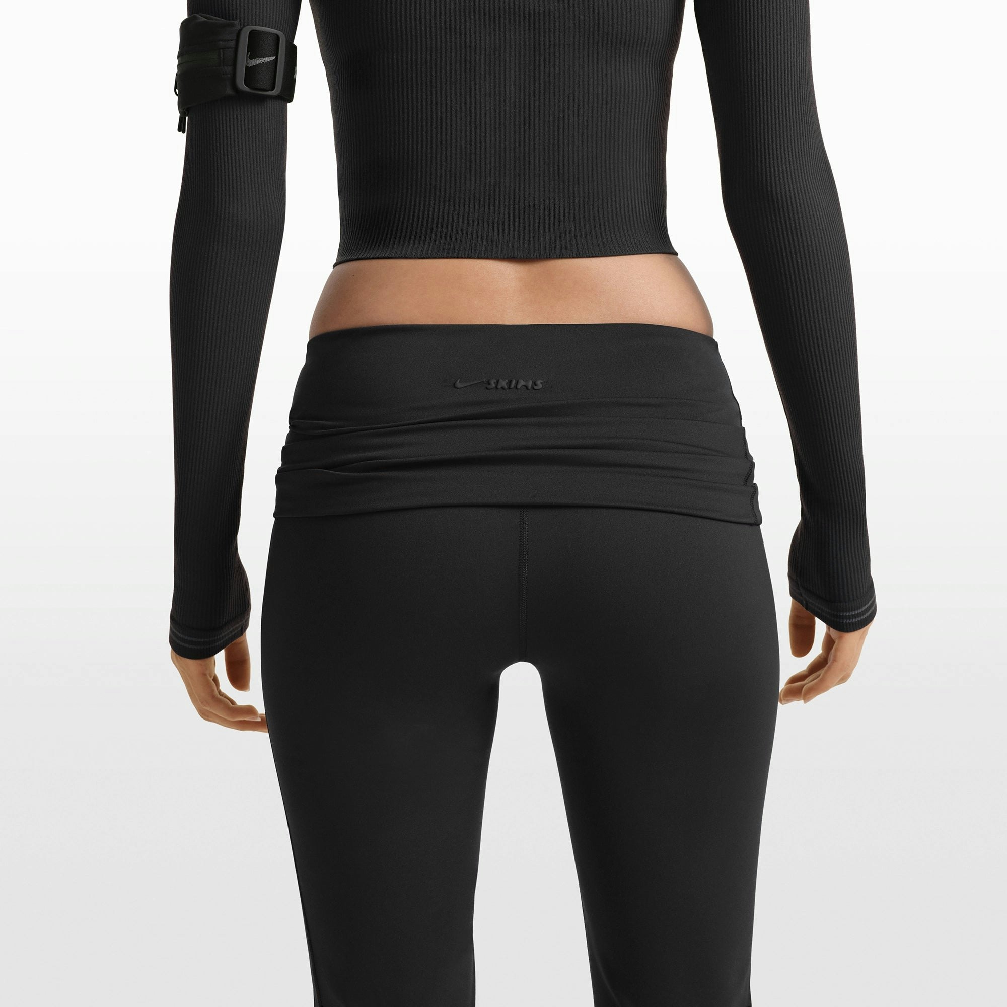NikeSKIMS MATTE FOLDOVER SLIM FLARE LEGGING | OBSIDIAN ON A MODEL FRONT VIEW @ | FOCUS: 0.0, 1.0, 0.9