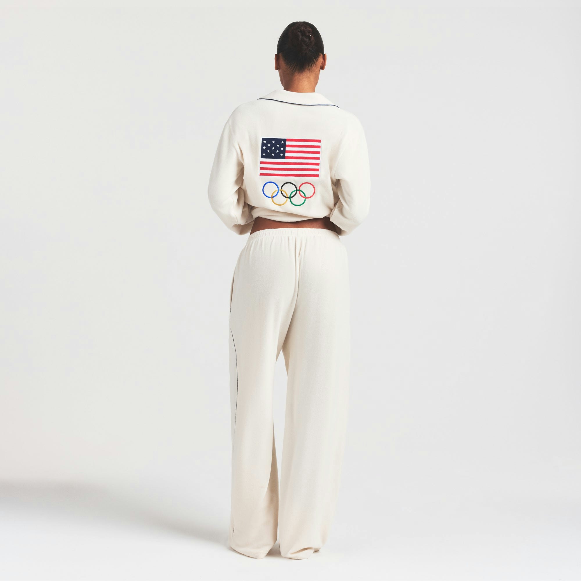 SKIMS FOR TEAM USA UNISEX FLEECE OLYMPIC SLEEP PANT | ECRU ON A MODEL FRONT VIEW @ | FOCUS: 0.0, 1.0, 0.9