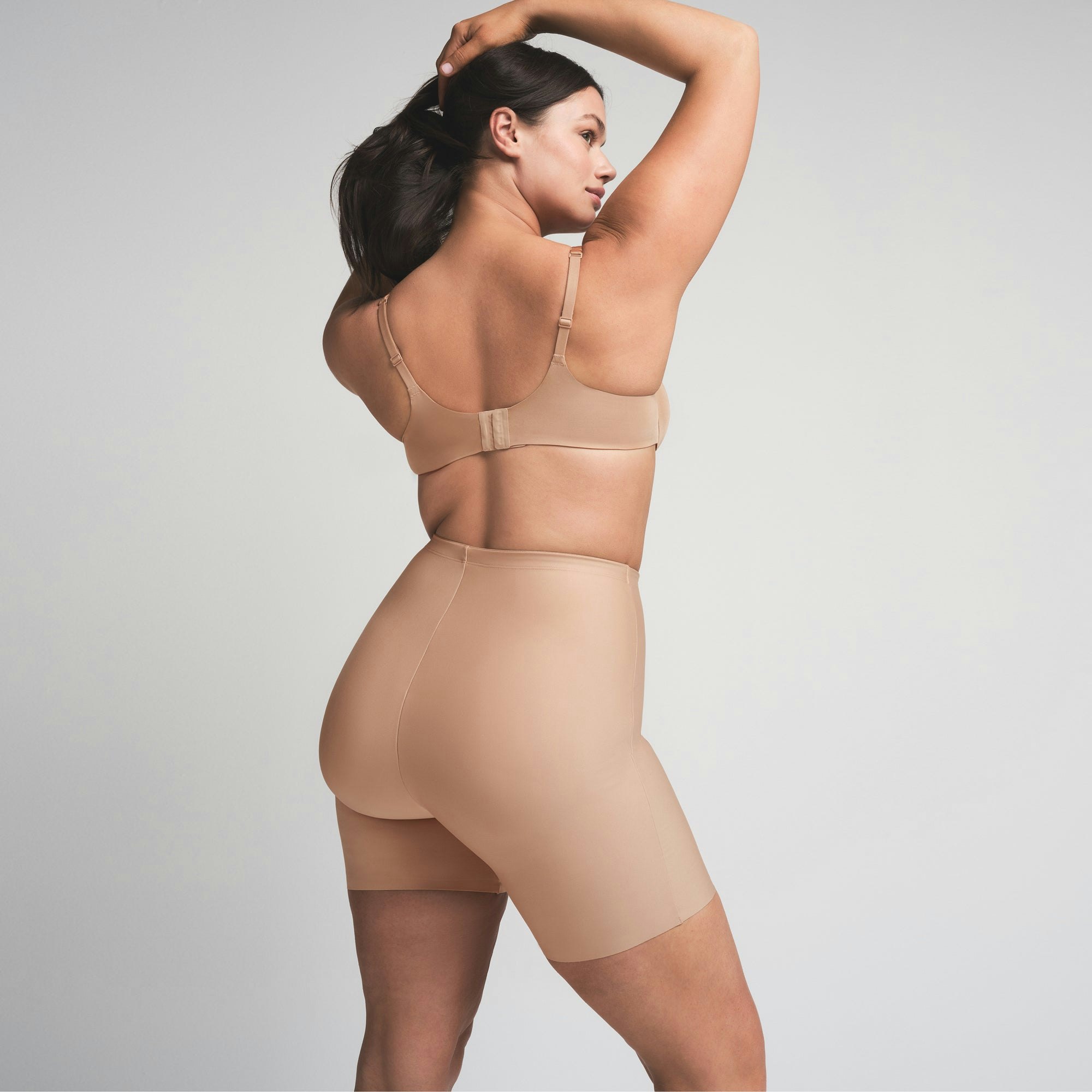 SKIMS BODY BUTT ENHANCING PADDED SHORT | CLAY  ON A MODEL SIDE VIEW | FOCUS: 0.0, 1.0, 0.9