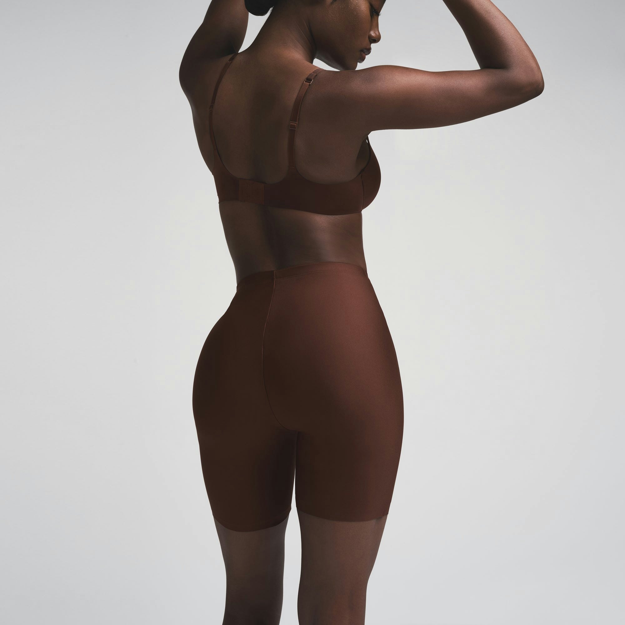 SKIMS BODY BUTT ENHANCING PADDED SHORT | COCOA ON A MODEL SIDE VIEW | FOCUS: 0.0, 1.0, 0.9