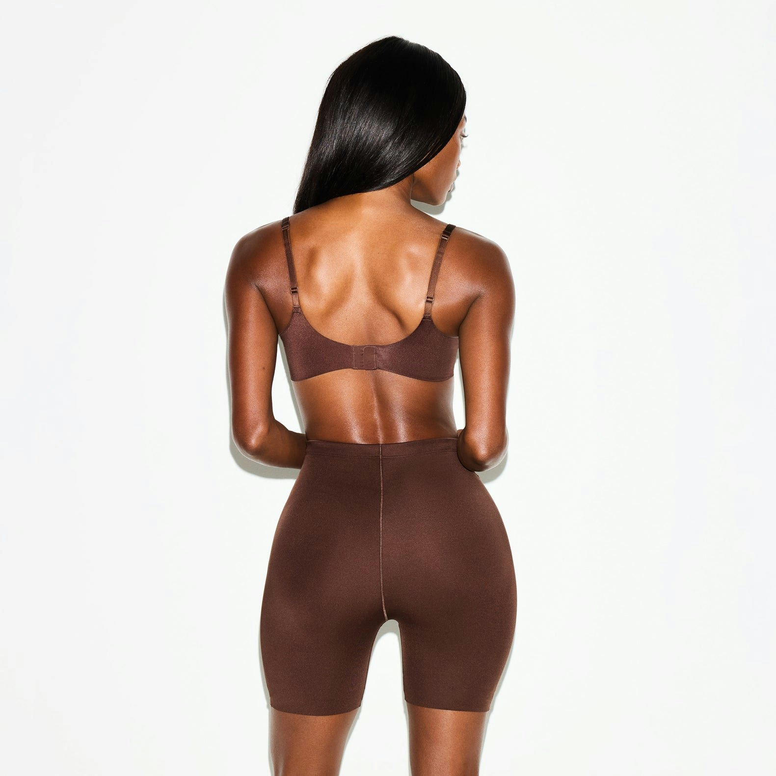 SKIMS BODY BUTT AND HIP ENHANCING MID THIGH SHORT | COCOA ON A MODEL SIDE VIEW @ | FOCUS: 0.0, 1.0, 0.9