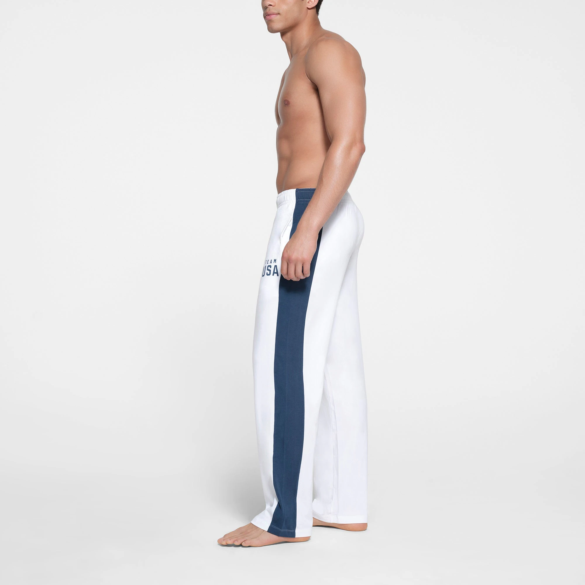 SKIMS FOR TEAM USA SKIMS COTTON MENS OLYMPIC PANT | WHITE ON A MODEL SIDE VIEW