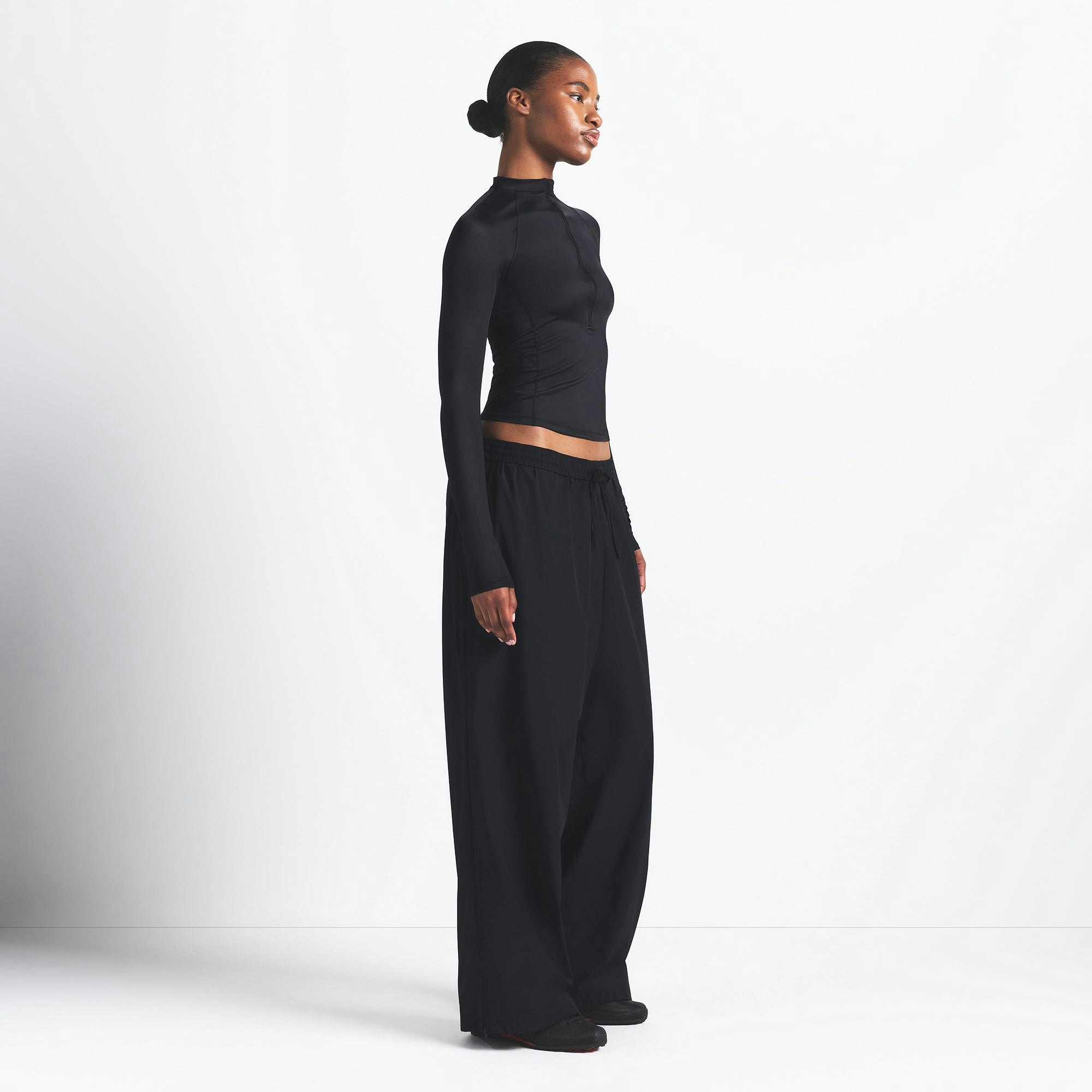 NikeSKIMS WOVEN NYLON OVERSIZED TRACK PANT | OBSIDIAN ON A MODEL SIDE VIEW @ | FOCUS: 0.0, 1.0, 0.9