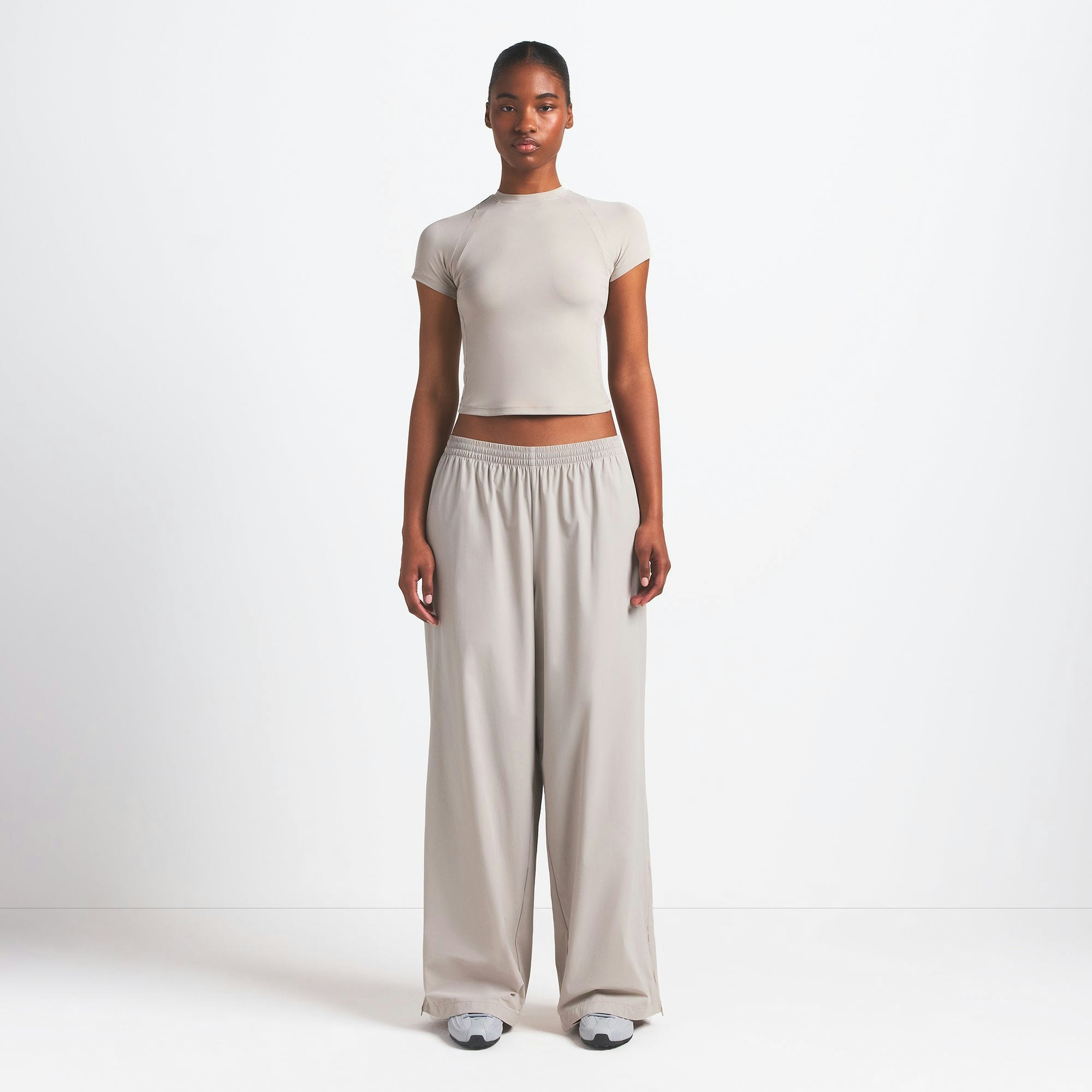 NikeSKIMS WOVEN NYLON OVERSIZED TRACK PANT | STONE ON A MODEL FRONT VIEW @ | FOCUS: 0.0, 1.0, 0.9