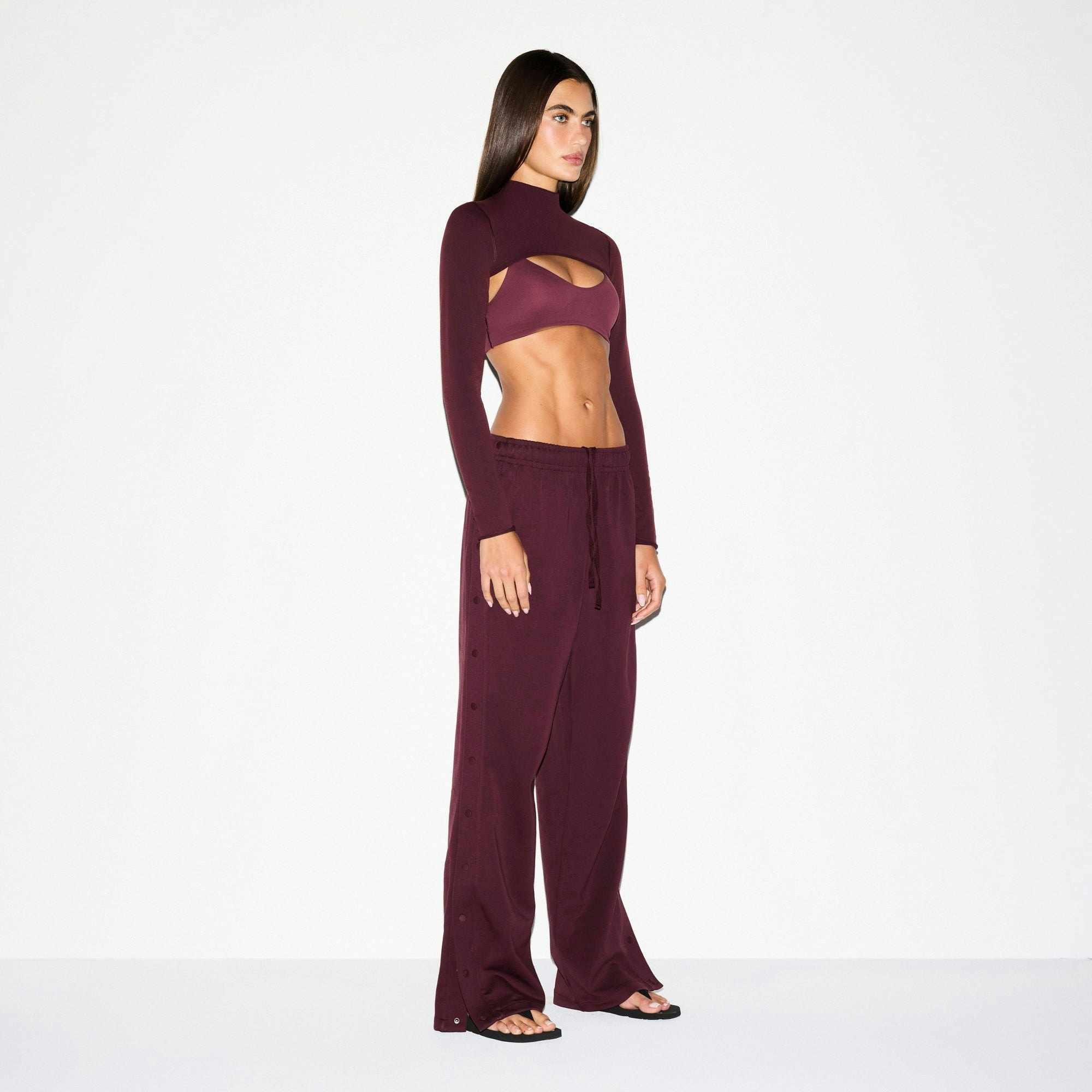 NikeSKIMS MATTE TRICOT SIDE SNAPS PANT | CURRANT ON A MODEL SIDE VIEW @ | FOCUS: 0.0, 1.0, 0.9