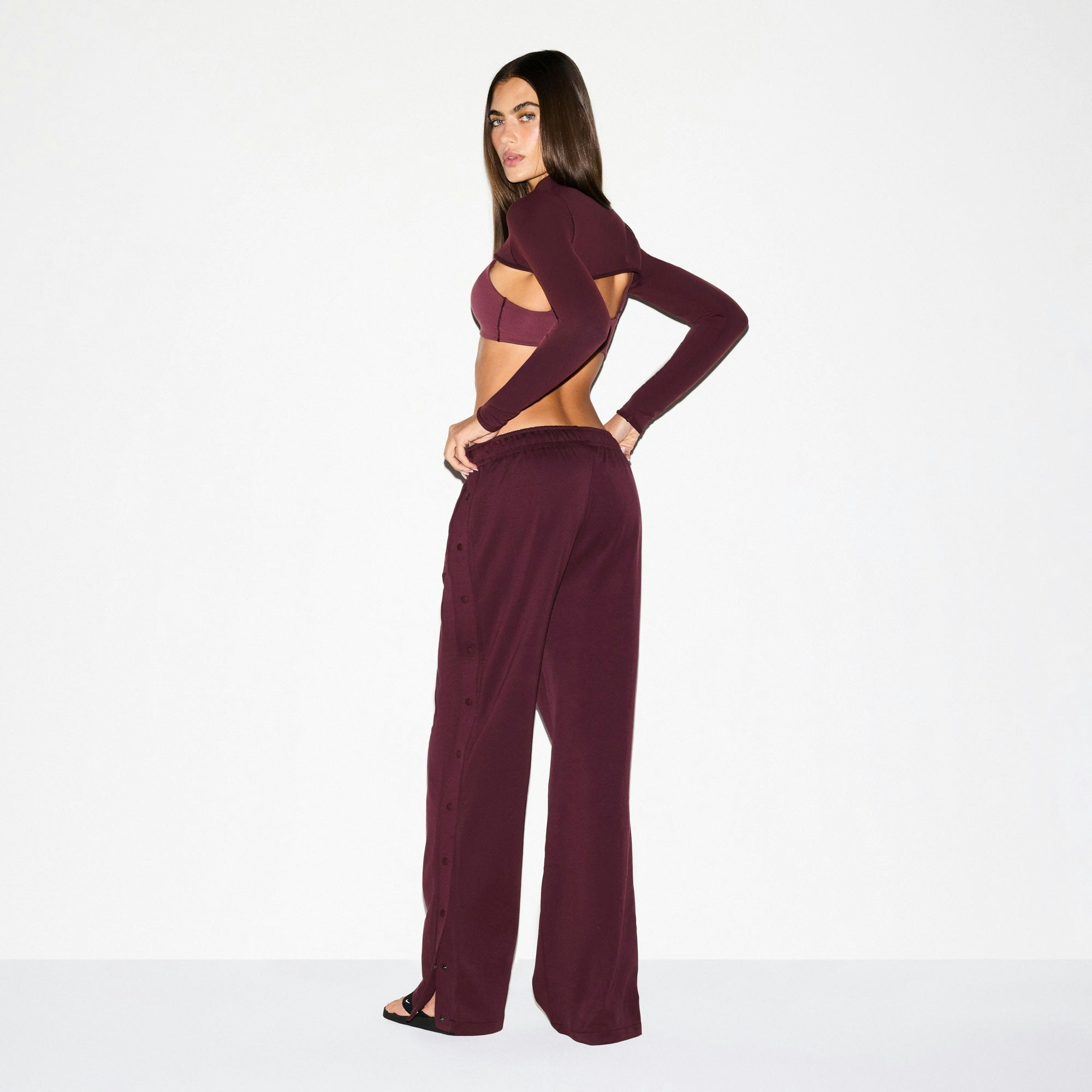 NikeSKIMS MATTE TRICOT SIDE SNAPS PANT | CURRANT ON A MODEL SIDE VIEW @ | FOCUS: 0.0, 1.0, 0.9