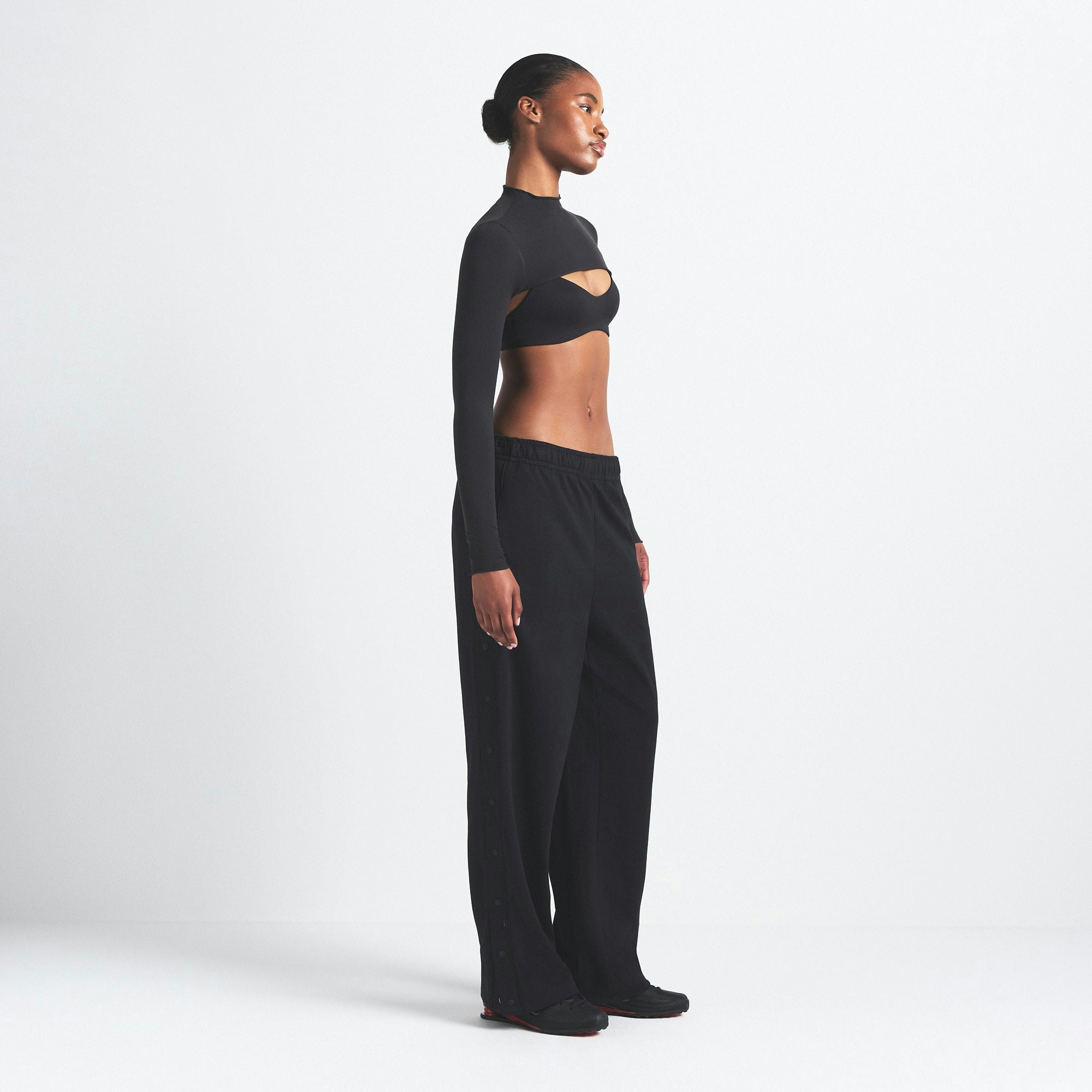 NikeSKIMS MATTE TRICOT SIDE SNAPS PANT | OBSIDIAN ON A MODEL SIDE VIEW @ | FOCUS: 0.9, 0.1, 0.7