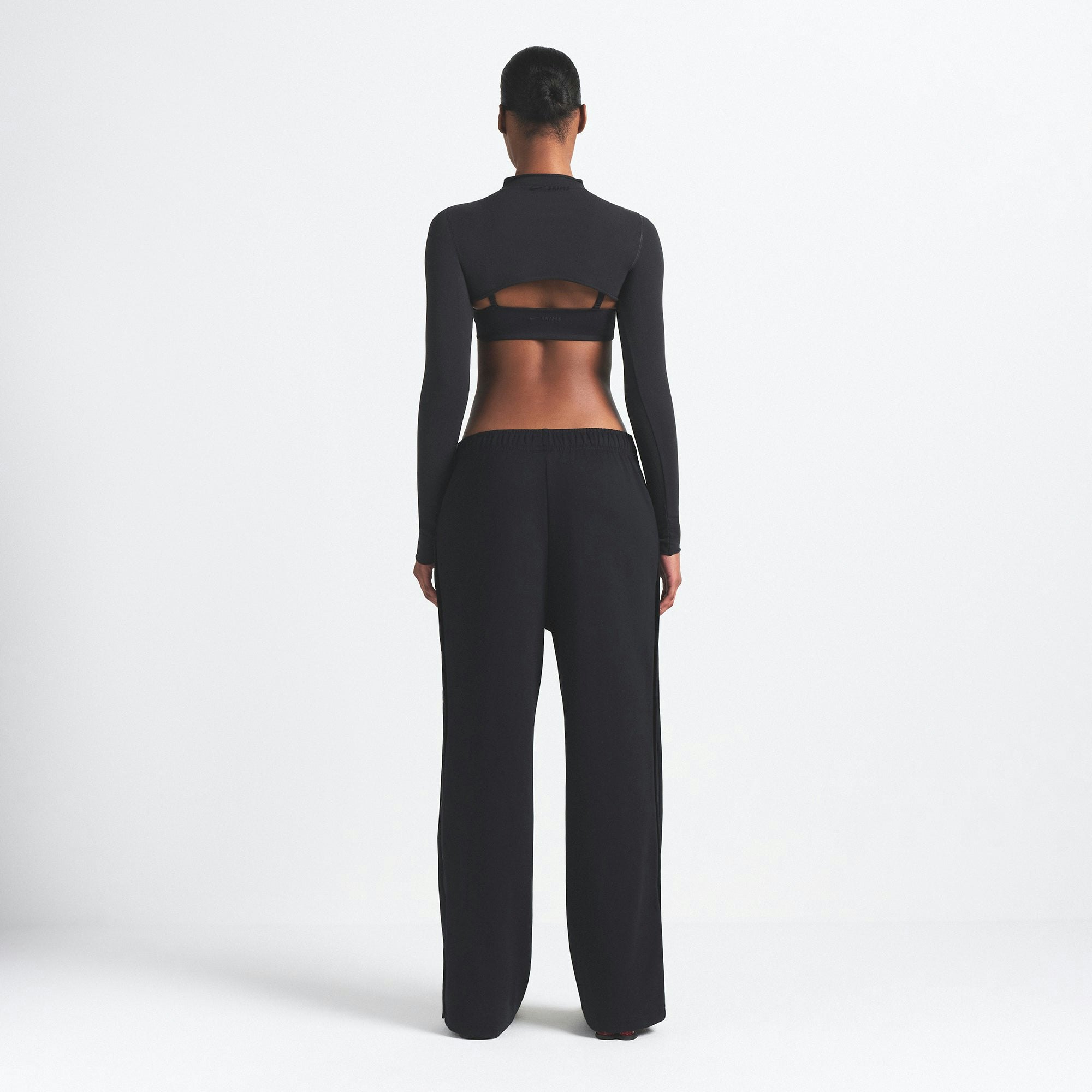 NikeSKIMS MATTE TRICOT SIDE SNAPS PANT | OBSIDIAN ON A MODEL SIDE VIEW @ | FOCUS: 0.9, 0.1, 0.7