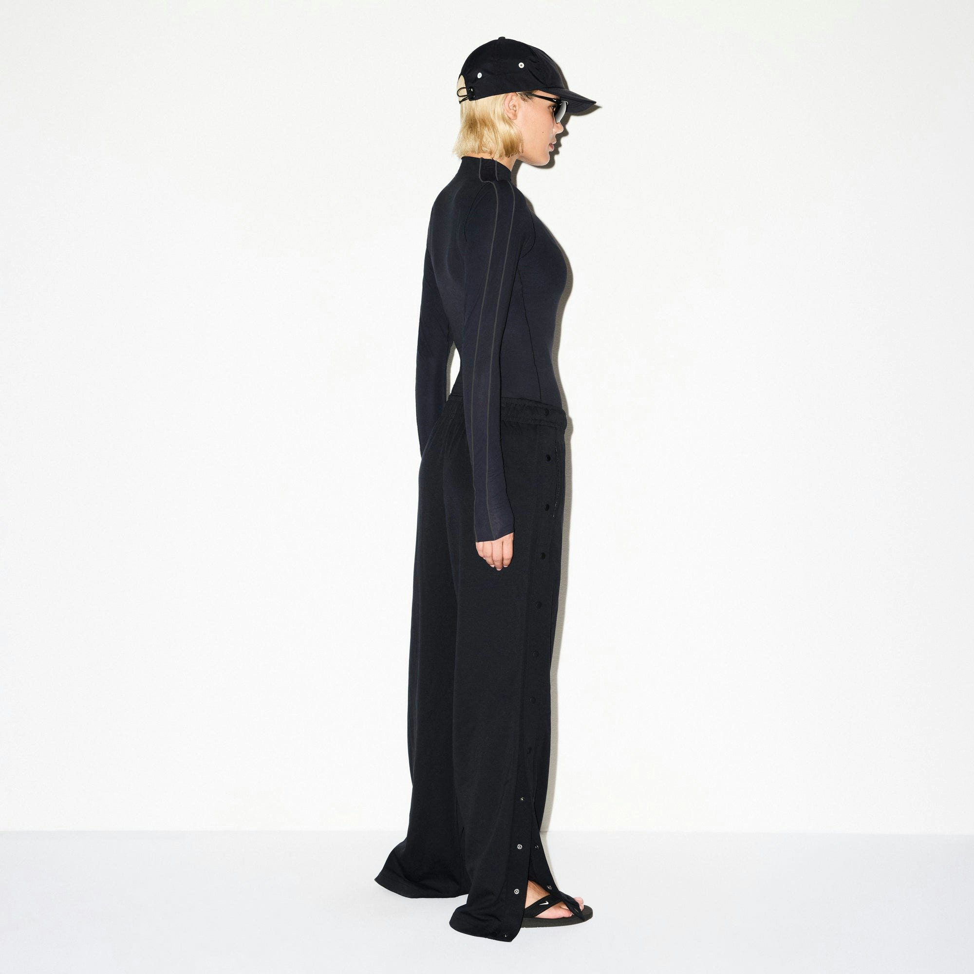 NikeSKIMS MATTE TRICOT SIDE SNAPS PANT | OBSIDIAN ON A MODEL SIDE VIEW @ | FOCUS: 0.0, 1.0, 0.9