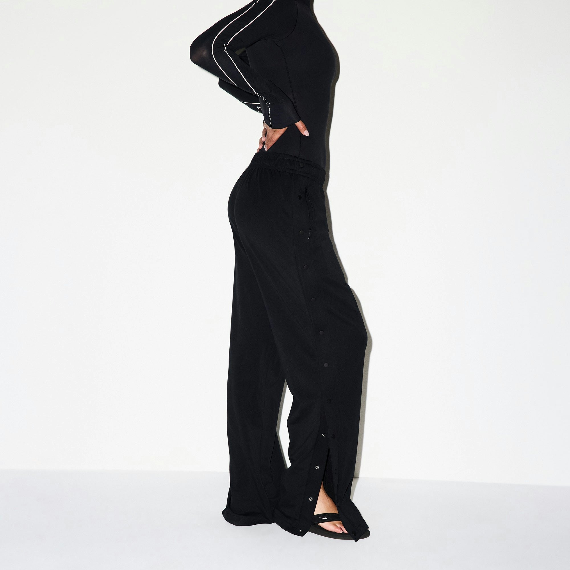 NikeSKIMS MATTE TRICOT SIDE SNAPS PANT | OBSIDIAN ON A MODEL SIDE VIEW @ | FOCUS: 0.0, 1.0, 0.9
