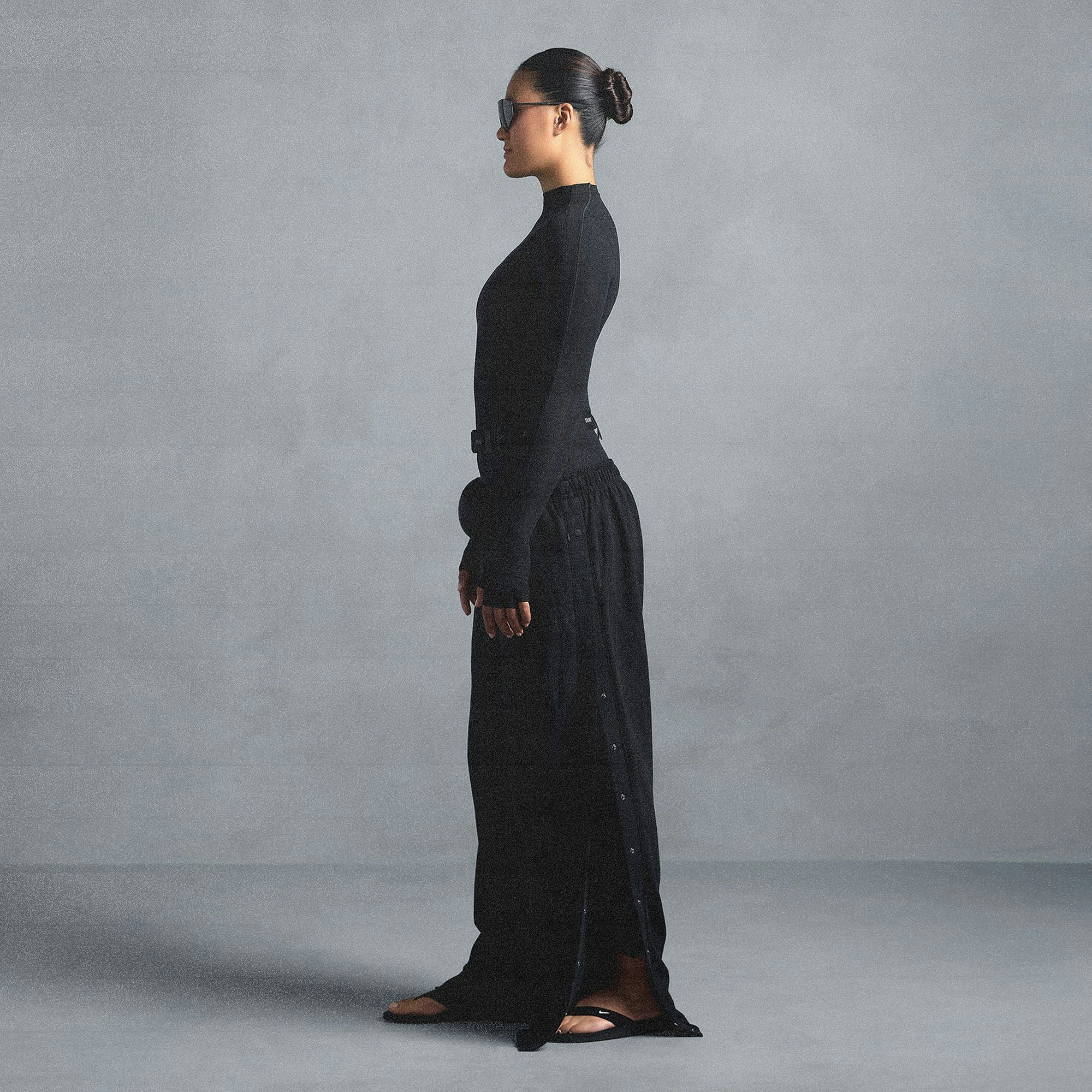 NikeSKIMS MATTE TRICOT SIDE SNAPS PANT | OBSIDIAN ON A MODEL SIDE VIEW @ | FOCUS: 0.0, 1.0, 0.9