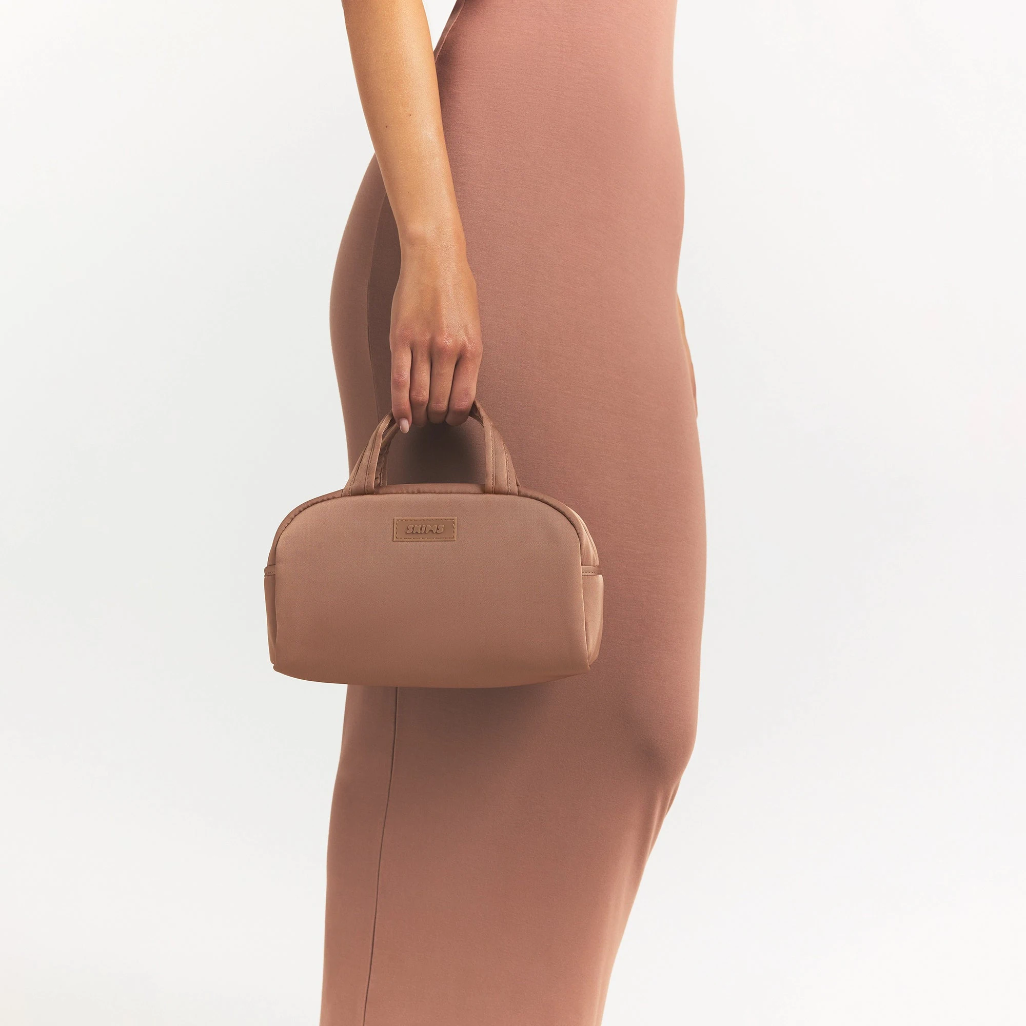 SKIMS ACCESSORIES SATIN MINI DUFFLE BAG | SIENNA ON A MODEL SIDE VIEW @ | FOCUS: 0.0, 1.0, 0.9