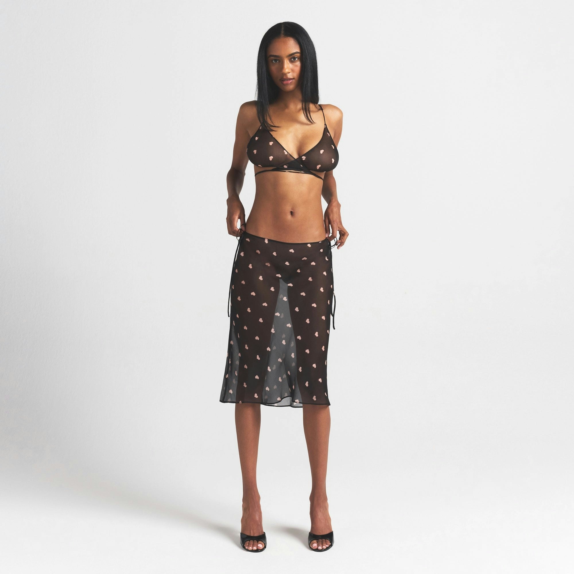 SKIMS ROMANCE SKIMPY WRAP BRALETTE | OBSIDIAN SPACED HEARTS ON A MODEL FRONT VIEW @ | FOCUS: 0.0, 1.0, 0.9