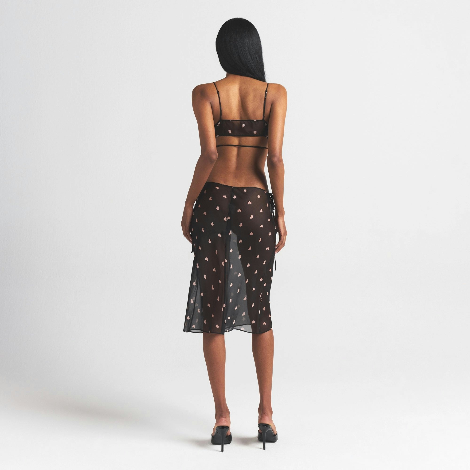 SKIMS ROMANCE SKIMPY WRAP BRALETTE | OBSIDIAN SPACED HEARTS ON A MODEL FRONT VIEW @ | FOCUS: 0.0, 1.0, 0.9