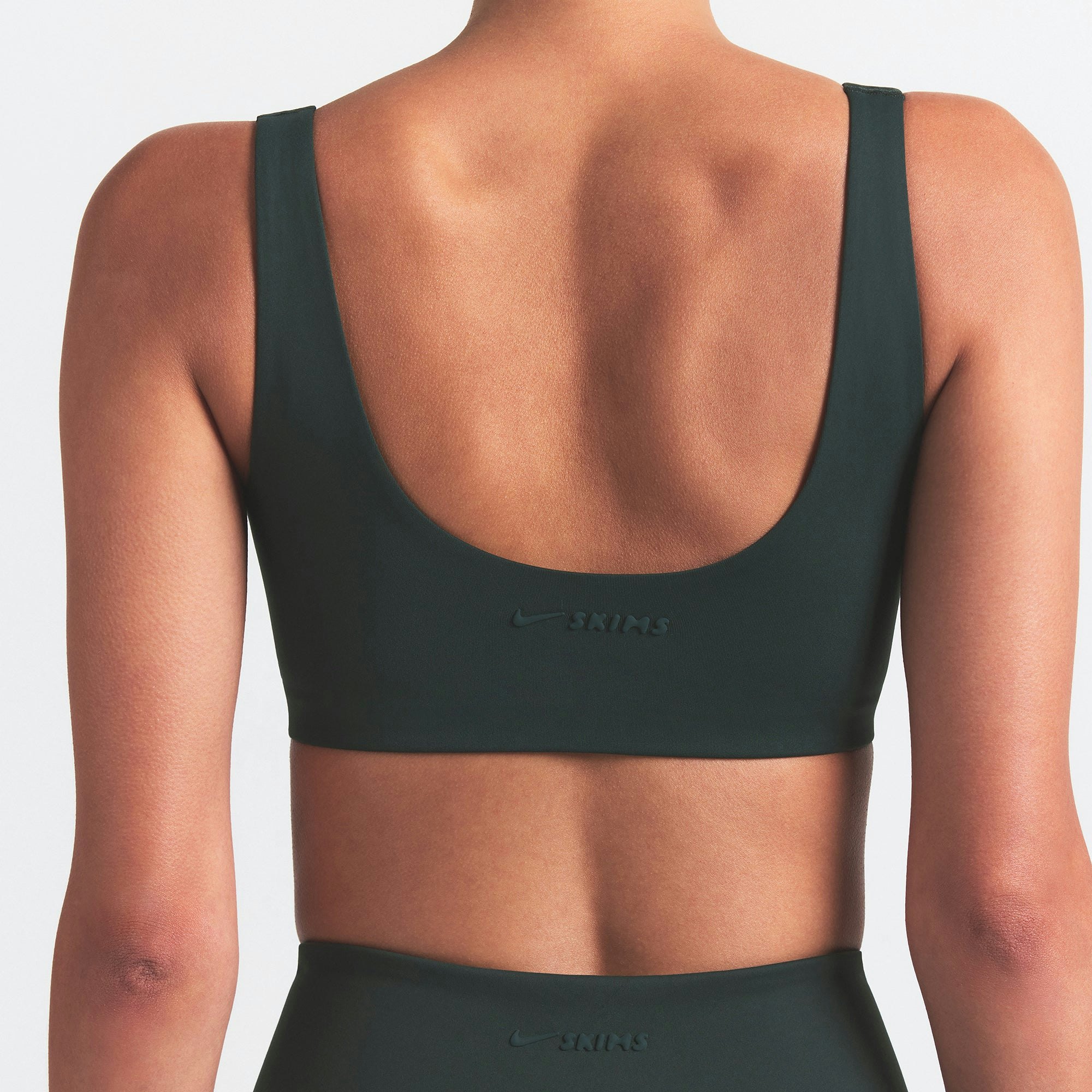 NikeSKIMS MATTE SCOOP NECK BRA | DARK TEAL ON A MODEL SIDE VIEW @ | FOCUS: 0.0, 1.0, 0.9