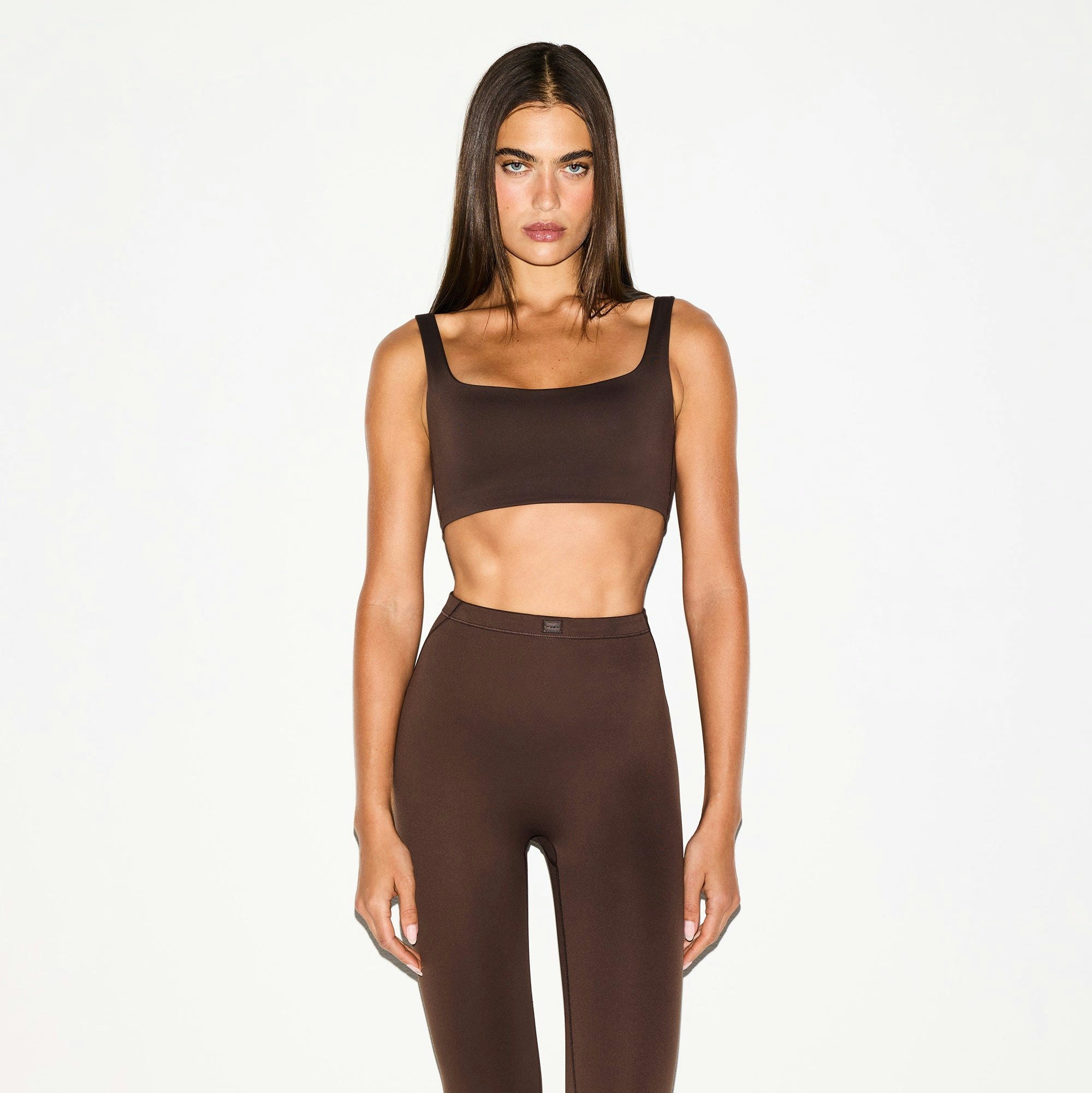 NikeSKIMS MATTE SCOOP NECK BRA | DARK SEPIA ON A MODEL FRONT VIEW @ | FOCUS: 0.0, 1.0, 0.9