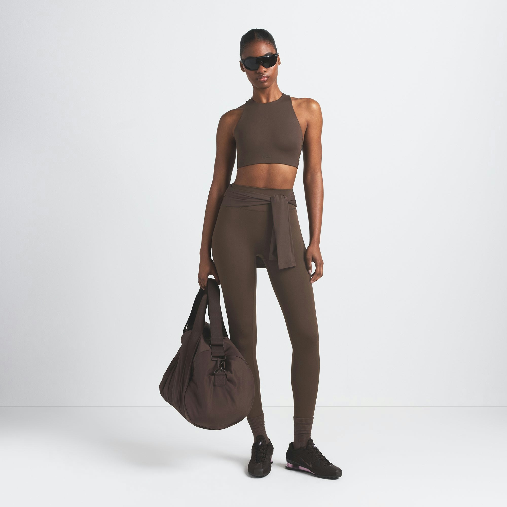 NikeSKIMS MATTE HIGH NECK BRA | DARK SEPIA ON A MODEL FRONT VIEW @ | FOCUS: 0.9, 0.1, 0.7