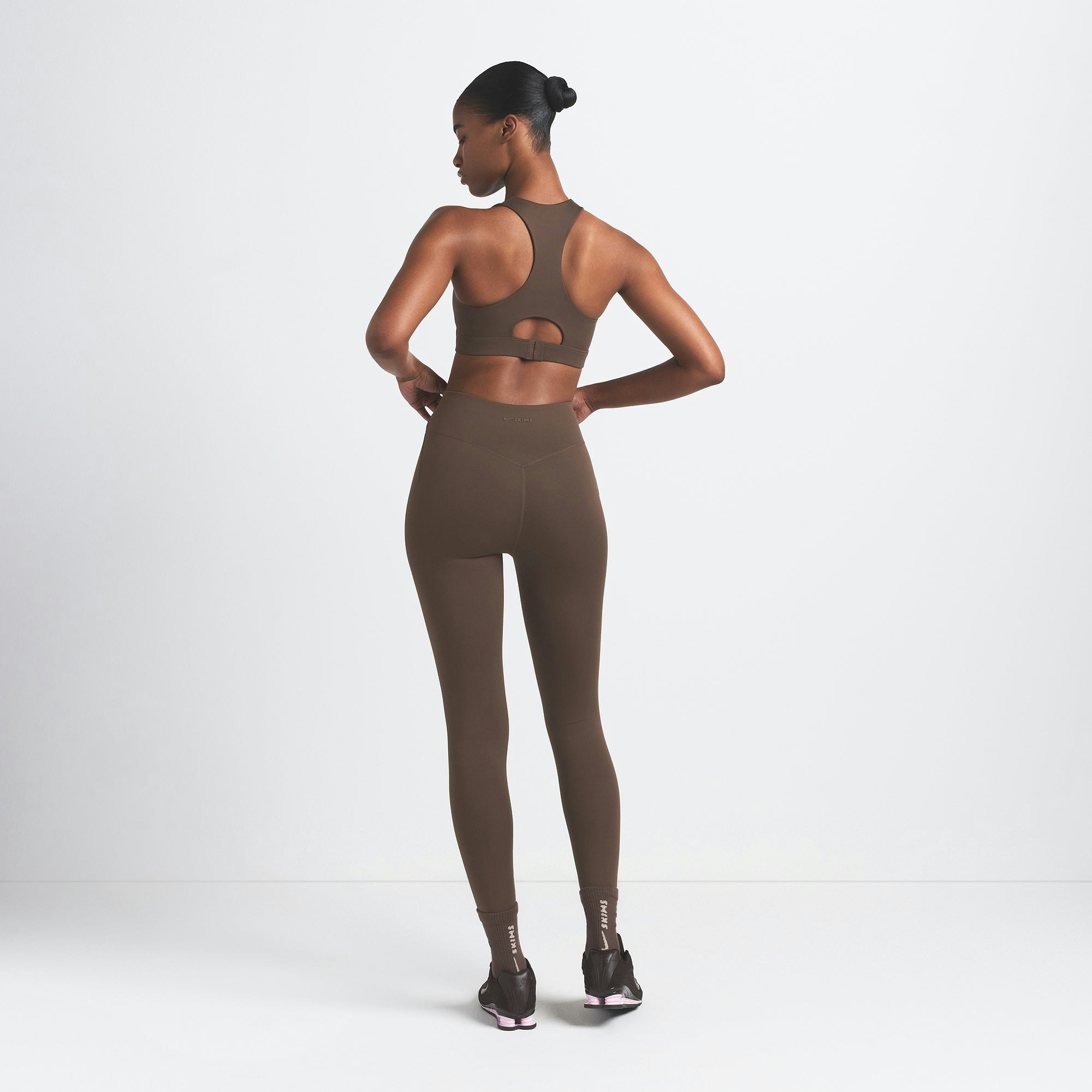 NikeSKIMS MATTE HIGH NECK BRA | DARK SEPIA ON A MODEL BACK VIEW