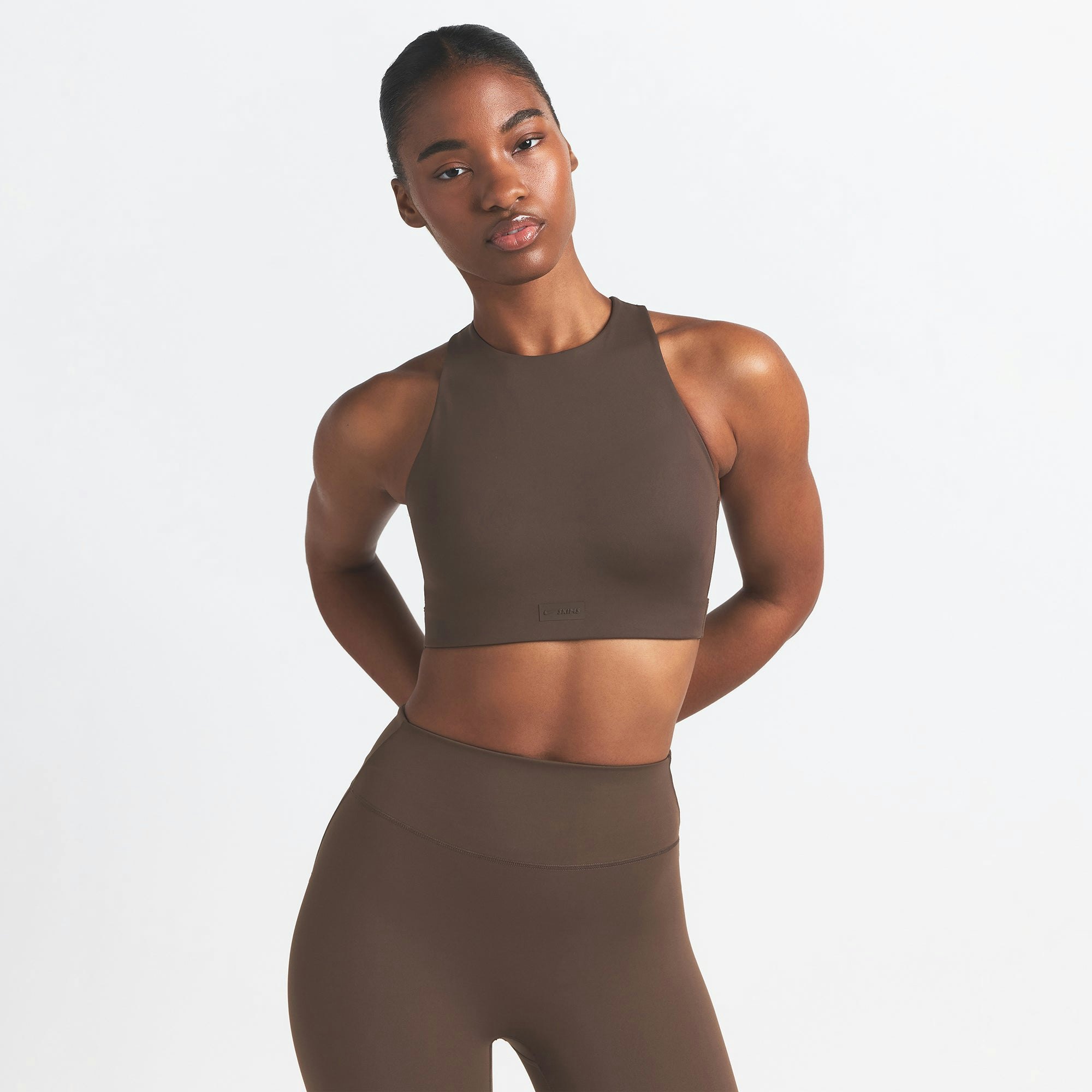 NikeSKIMS MATTE HIGH NECK BRA | DARK SEPIA ON A MODEL FRONT VIEW