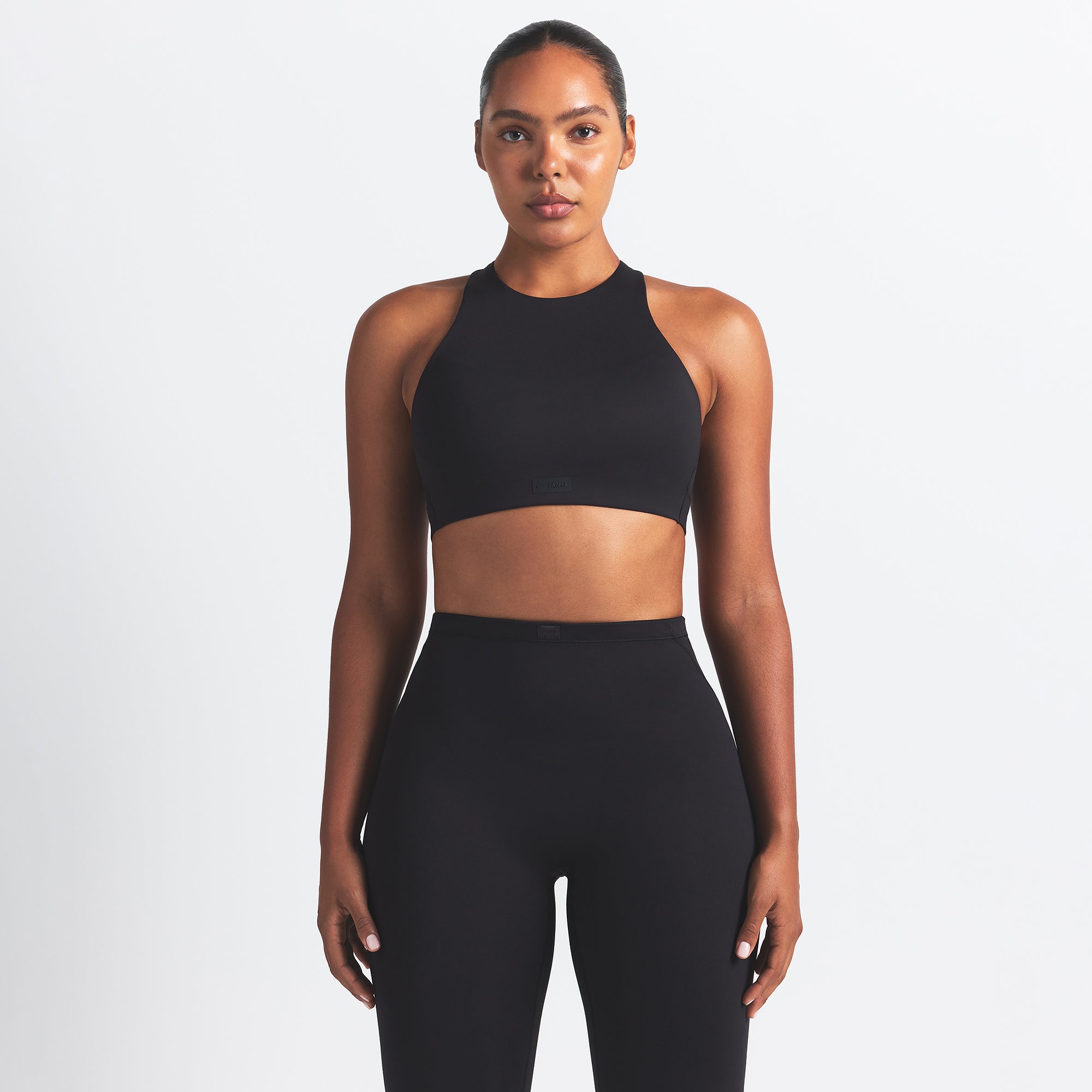 NikeSKIMS MATTE HIGH NECK BRA | OBSIDIAN ON A MODEL FRONT VIEW @ | FOCUS: 0.0, 1.0, 0.9