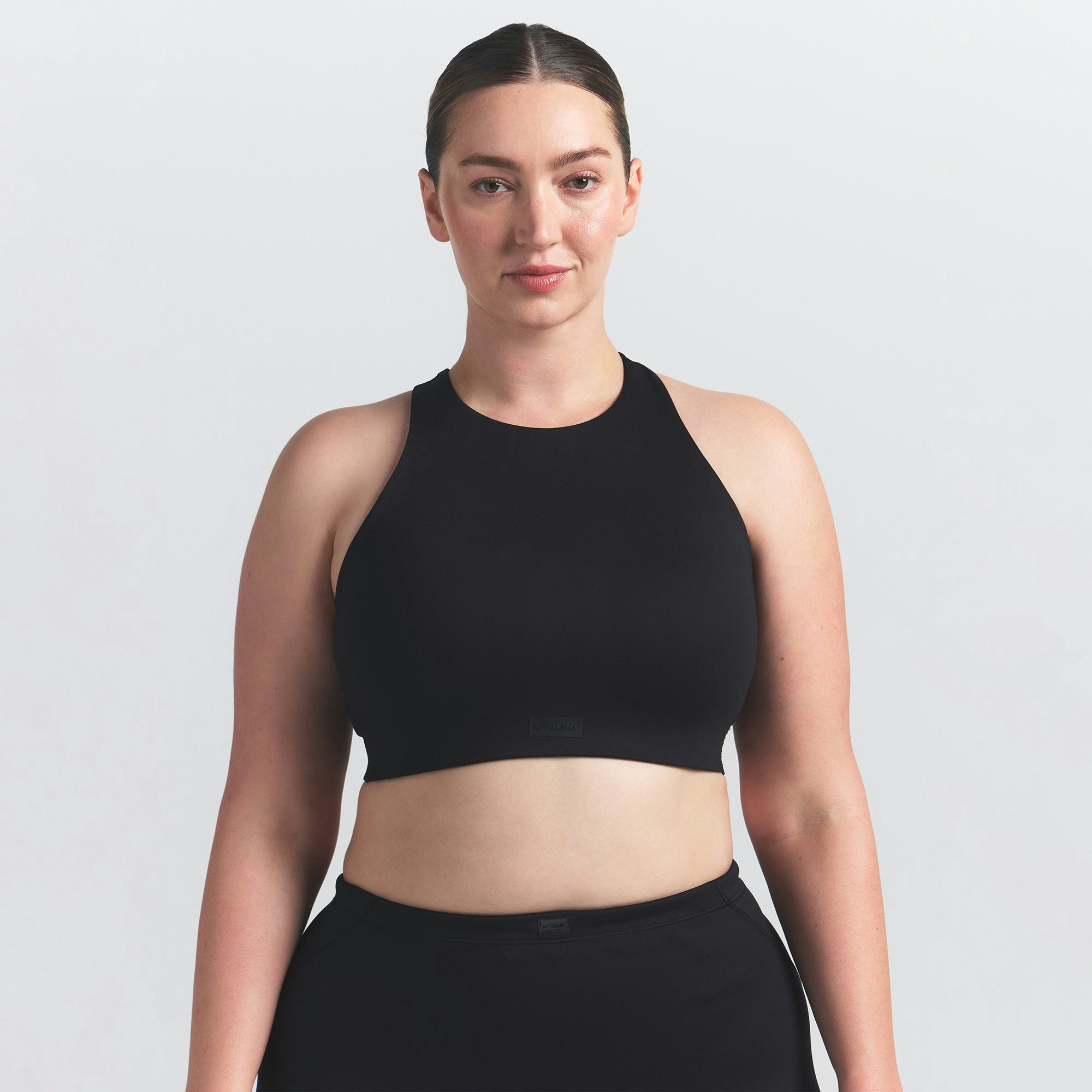 NikeSKIMS MATTE HIGH NECK BRA | OBSIDIAN ON A MODEL FRONT VIEW