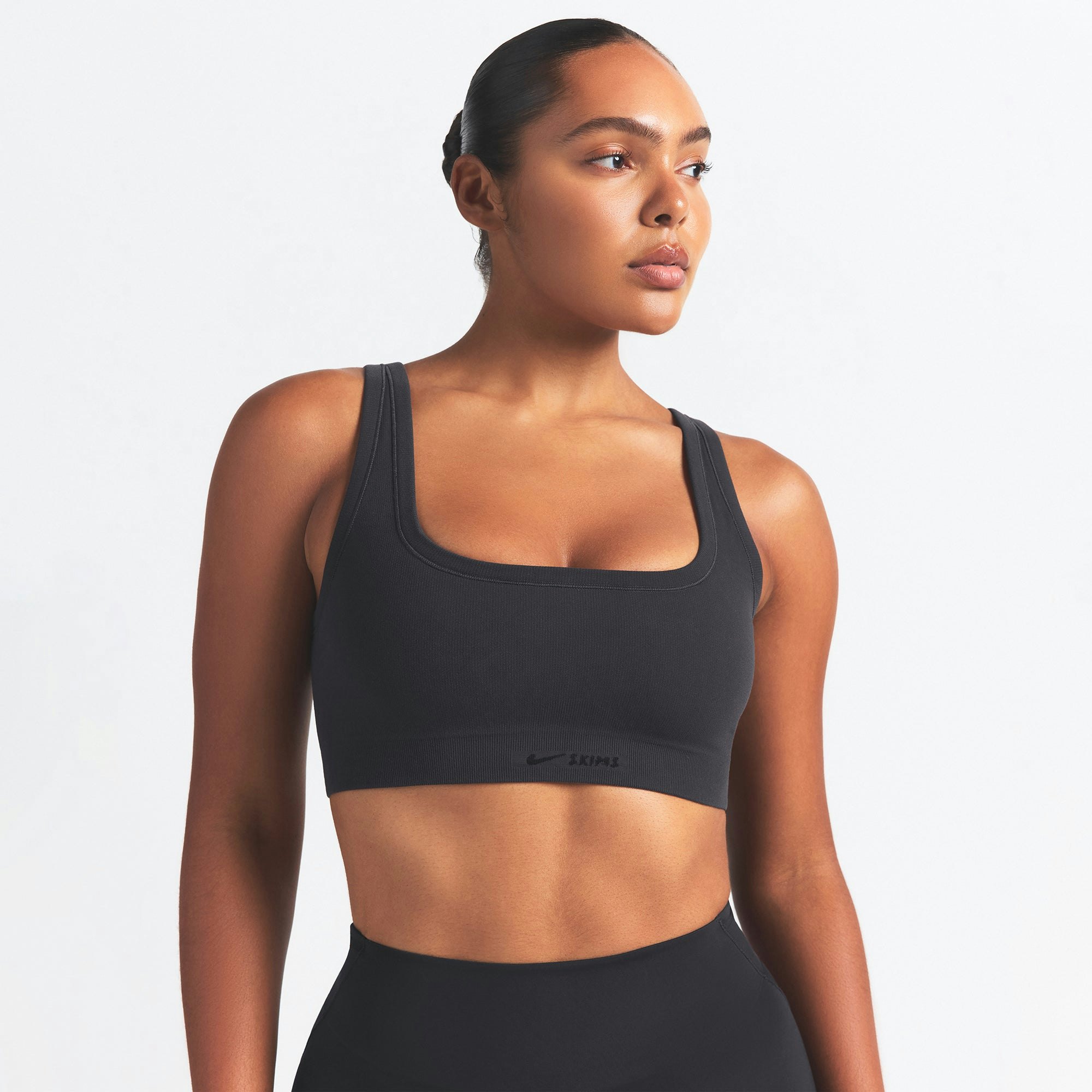 NikeSKIMS VINTAGE SEAMLESS SCOOP NECK BRA | OBSIDIAN ON A MODEL SIDE VIEW @ | FOCUS: 0.9, 0.1, 0.7