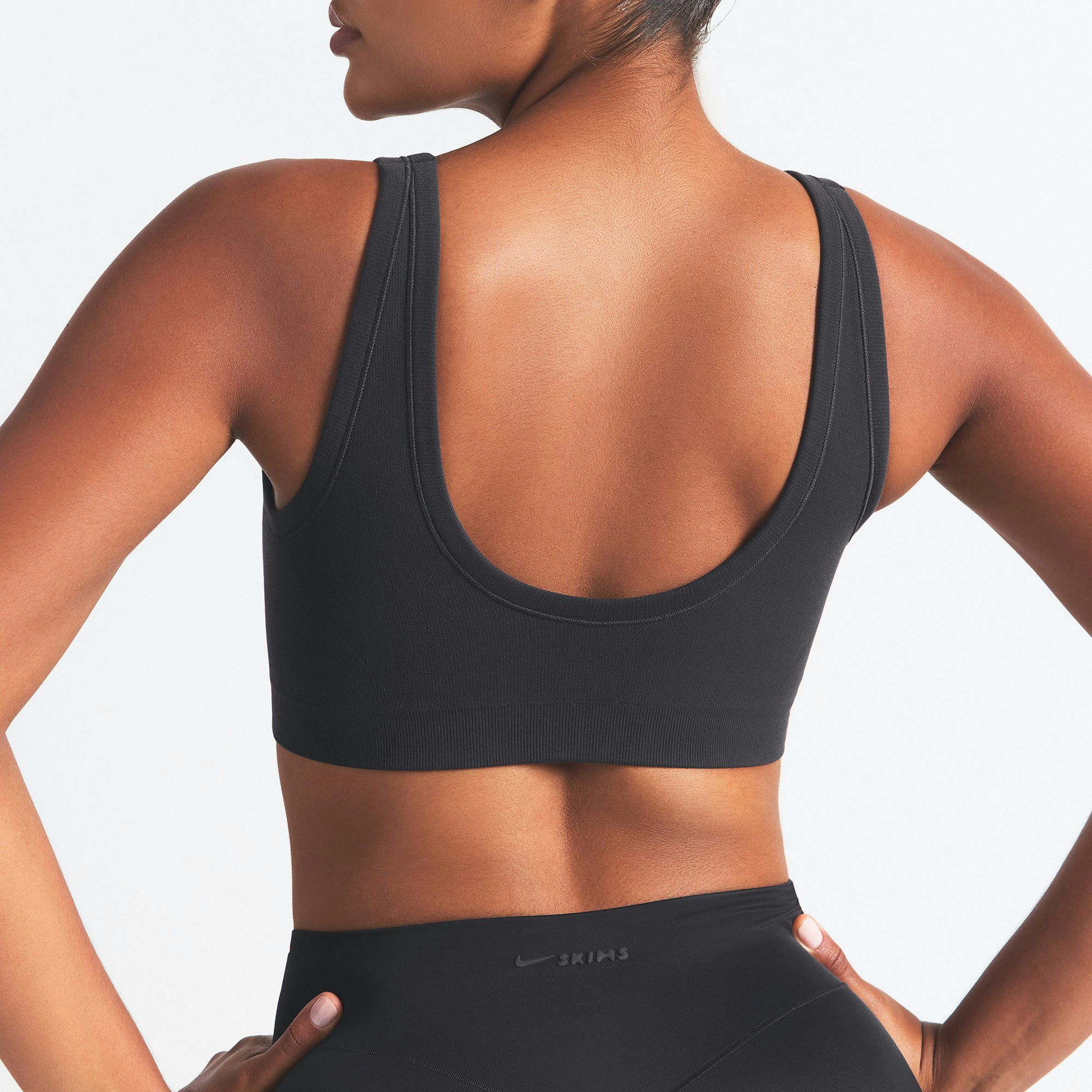 NikeSKIMS VINTAGE SEAMLESS SCOOP NECK BRA | OBSIDIAN ON A MODEL SIDE VIEW @ | FOCUS: 0.9, 0.1, 0.7