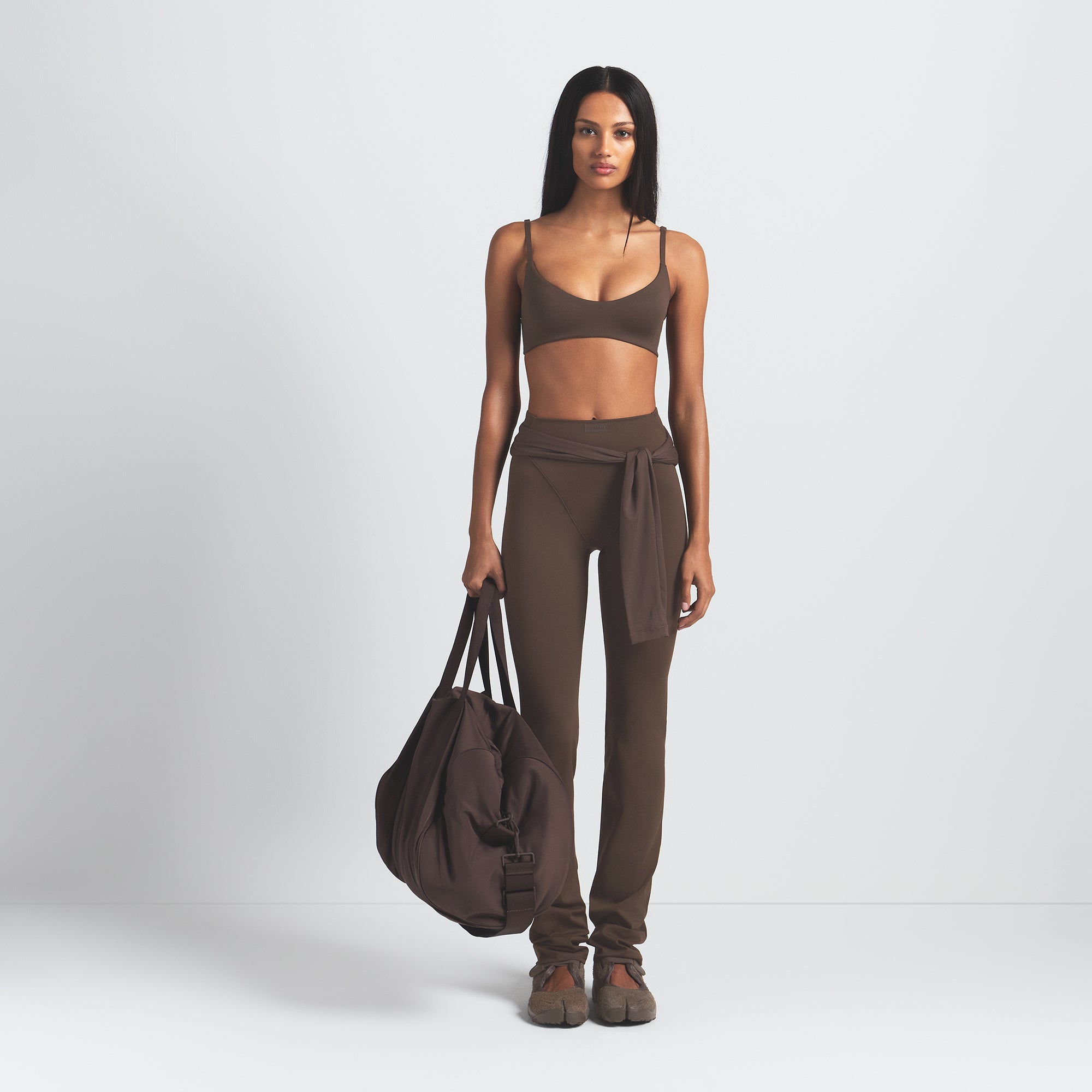 NikeSKIMS MATTE MICRO SCOOP BRA | DARK SEPIA ON A MODEL FRONT VIEW @ | FOCUS: 0.9, 0.1, 0.7