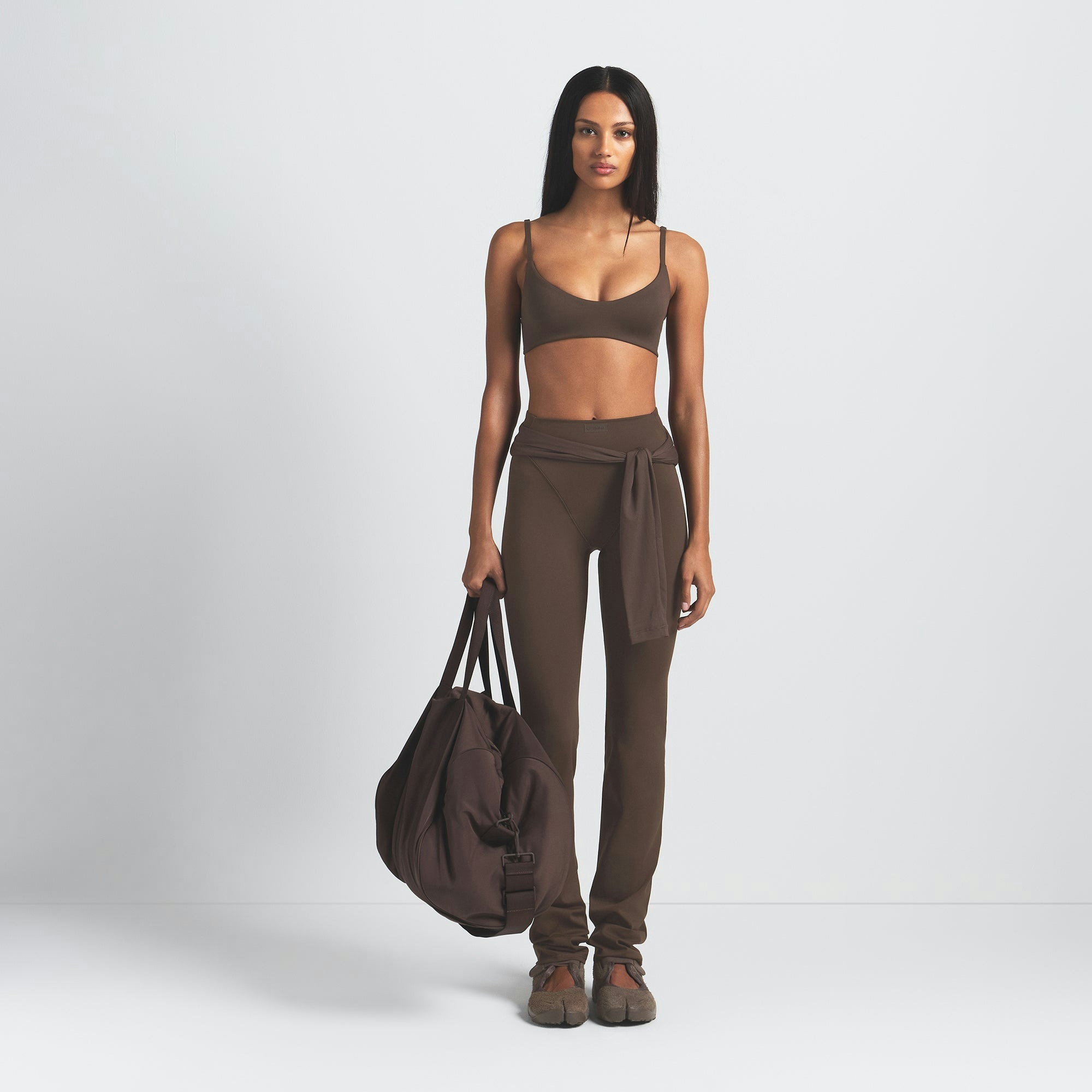 NikeSKIMS MATTE MICRO SCOOP BRA | DARK SEPIA ON A MODEL FRONT VIEW @ | FOCUS: 0.9, 0.1, 0.7