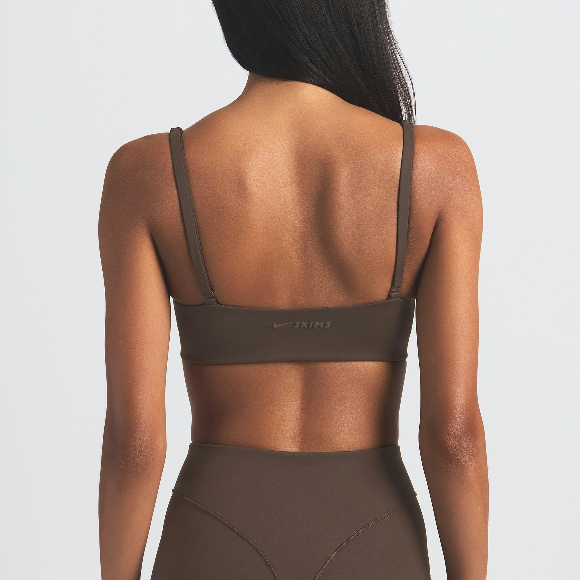 NikeSKIMS MATTE MICRO SCOOP BRA | DARK SEPIA ON A MODEL BACK VIEW