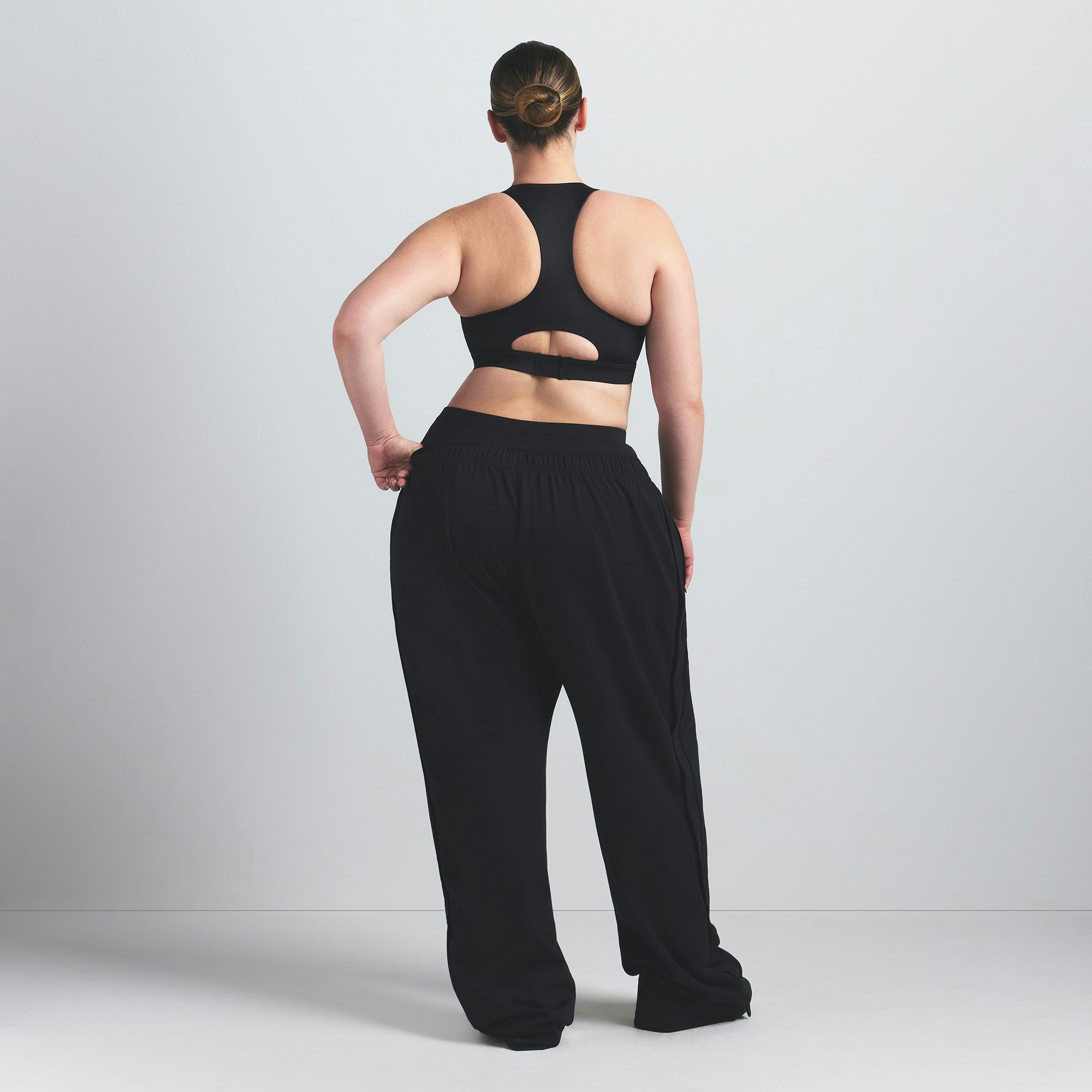 NikeSKIMS SHINE HIGH NECK BRA | OBSIDIAN ON A MODEL FRONT VIEW